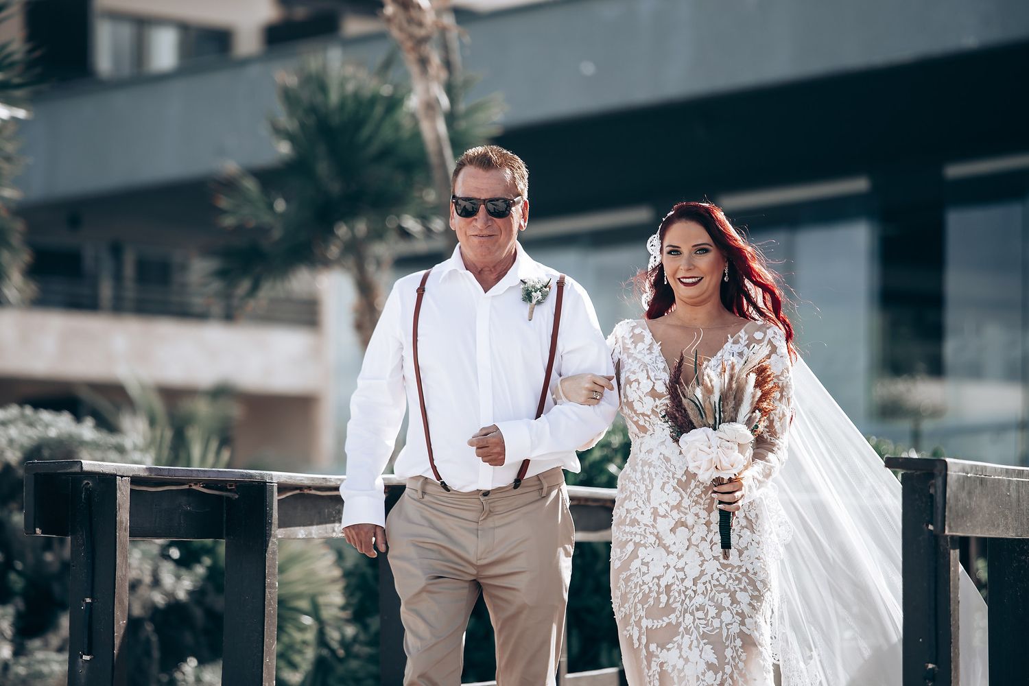 Wedding party walking along a pristine white sand beach in formal attire.