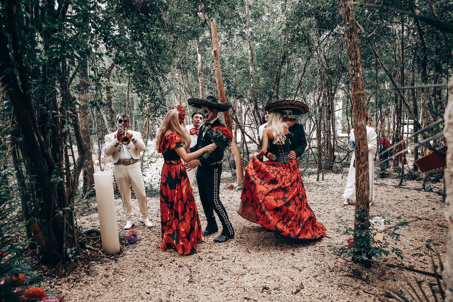 A Day of the Dead themed photoshoot in a wooded area with stone walls and dramatic lighting.
