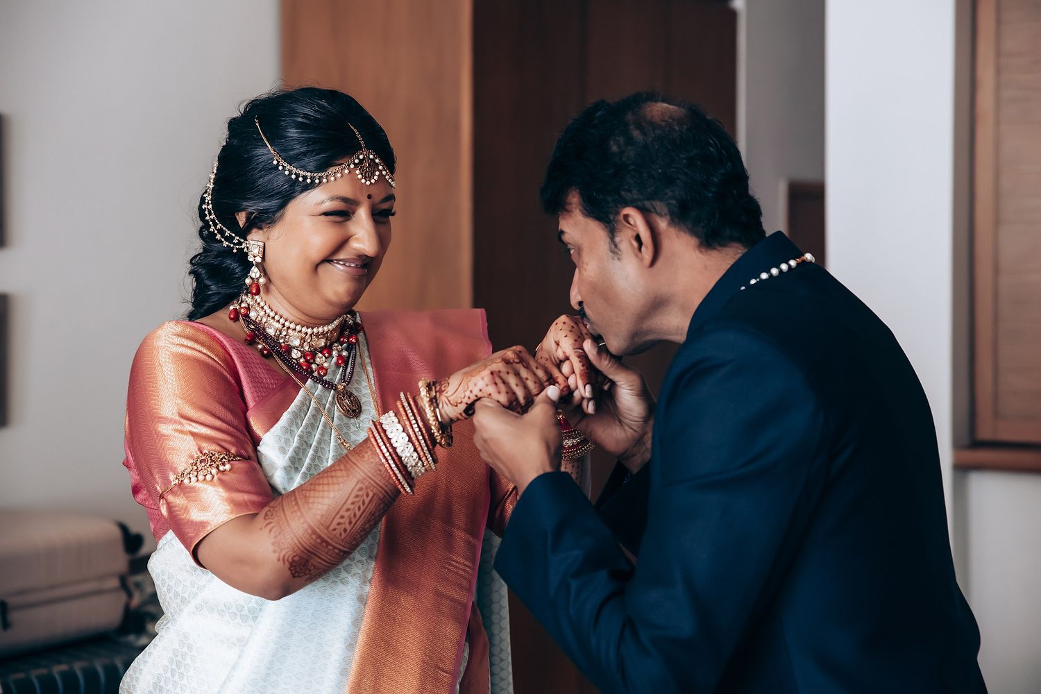 Traditional blessing ceremony with participants wearing formal Indian attire in pink and navy.