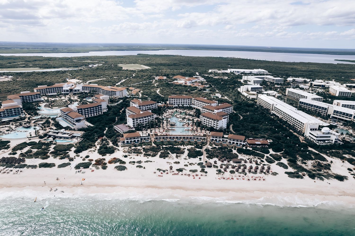 Aerial view of a coastal resort town with buildings, beaches, and water in the background.