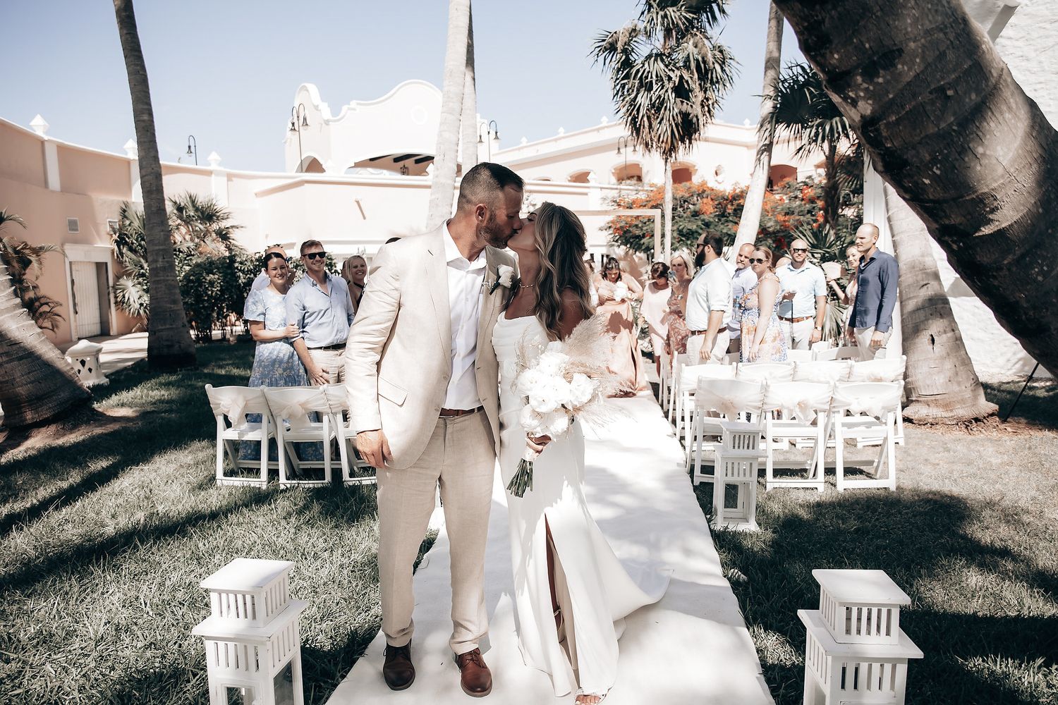 A couple is walking down an aisle at a wedding ceremony.
