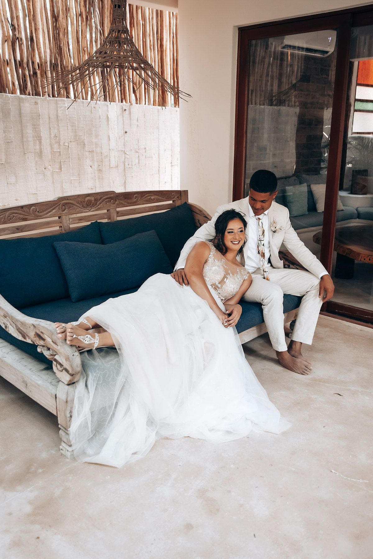 Romantic couple in wedding attire sharing intimate moments on a daybed.