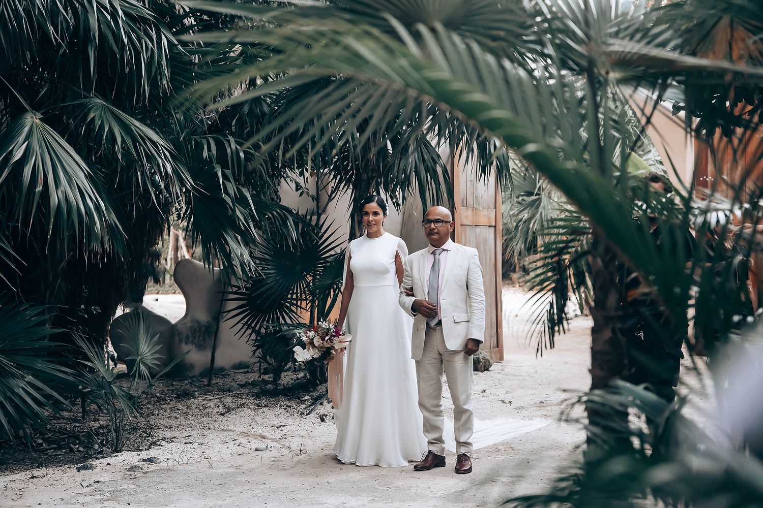 Wedding ceremony setup with palm trees and natural lighting creating a romantic atmosphere.