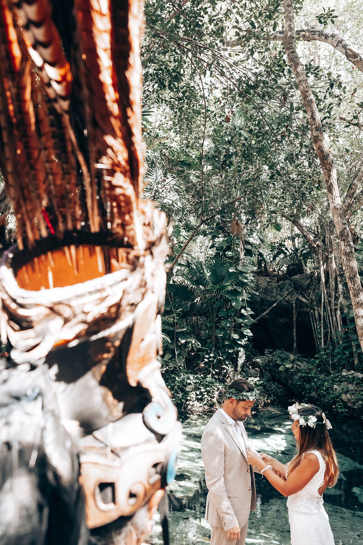 White and natural wood decorations set against lush tropical forest background.