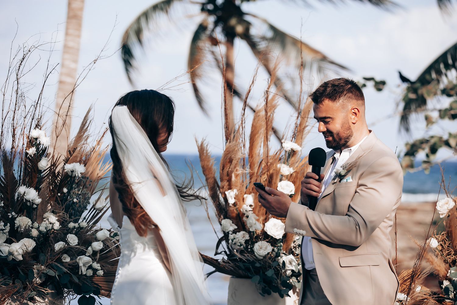 A couple shares an intimate moment during their outdoor winter wedding ceremony surrounded by snow and pine trees.