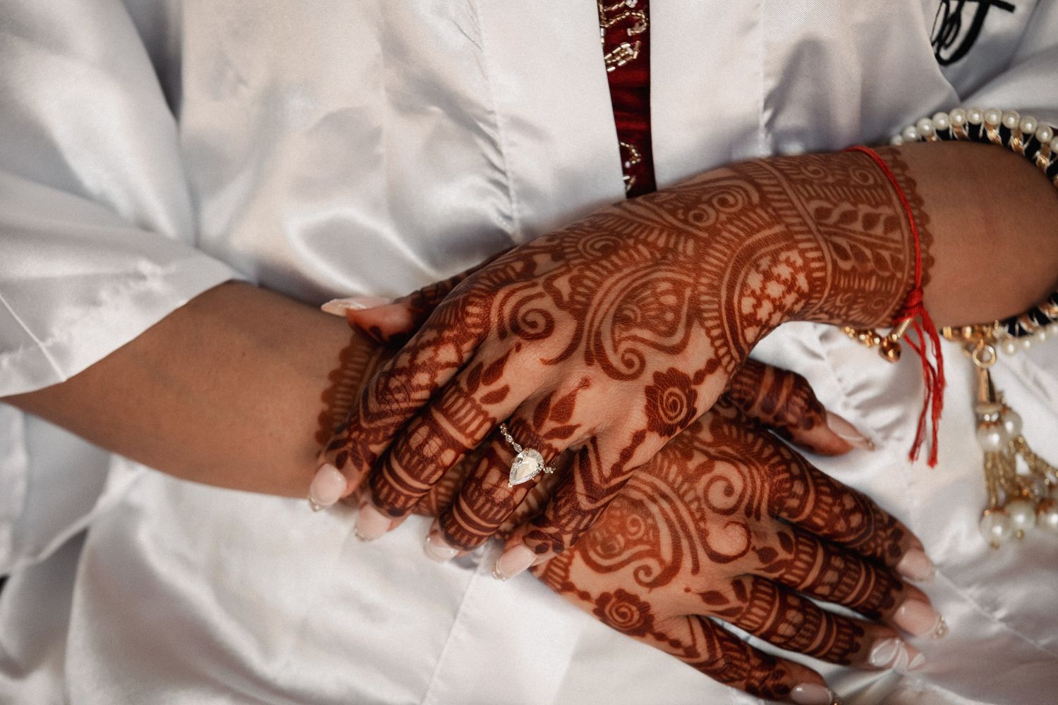 Close-up of intricate henna mehndi design on bride's hands during traditional wedding ceremony.