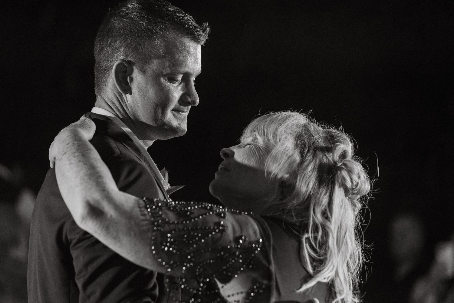 Black and white romantic close-up of a couple sharing a tender dance at their wedding reception.