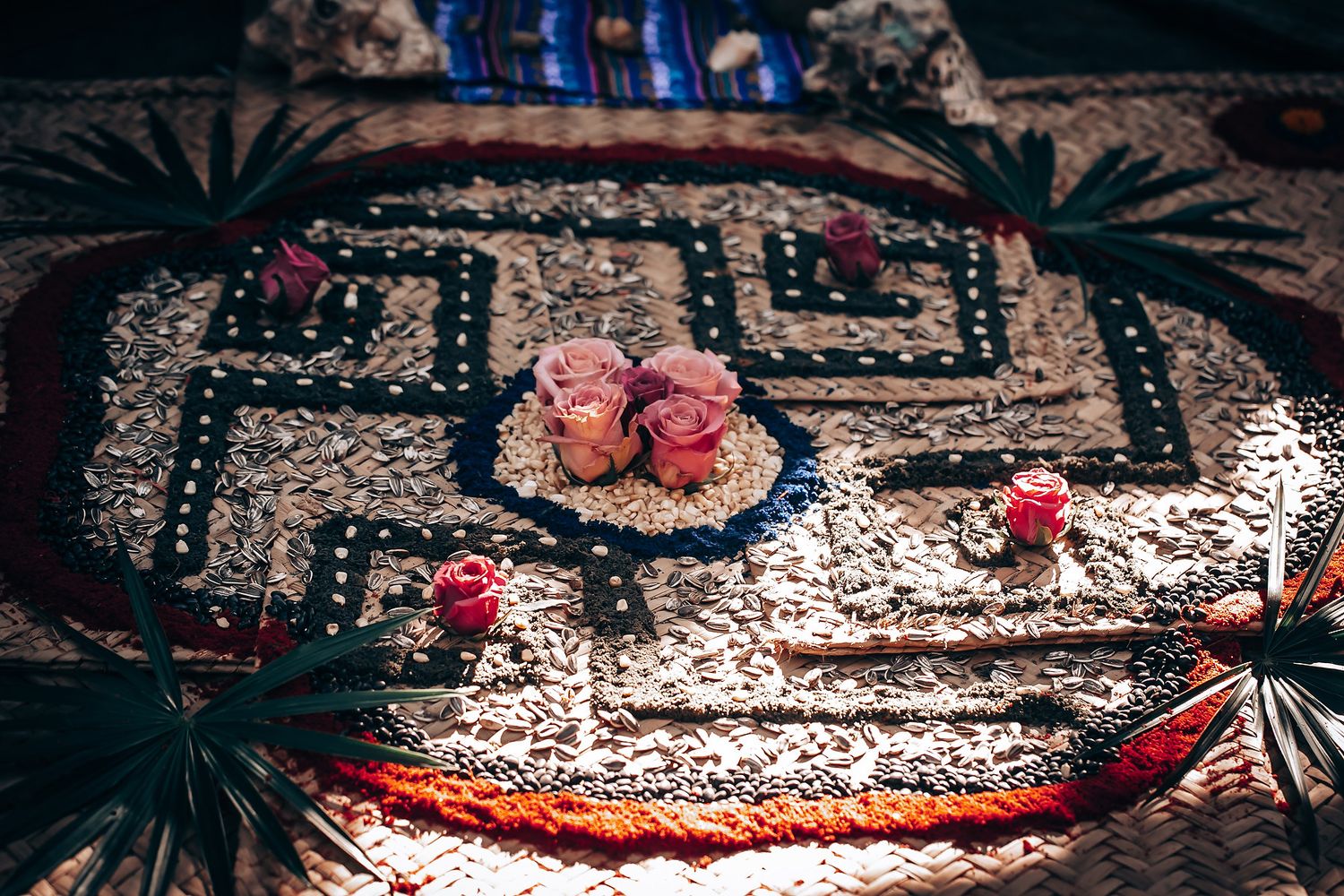 Traditional patterned rug with pink roses arranged on geometric design in warm lighting.