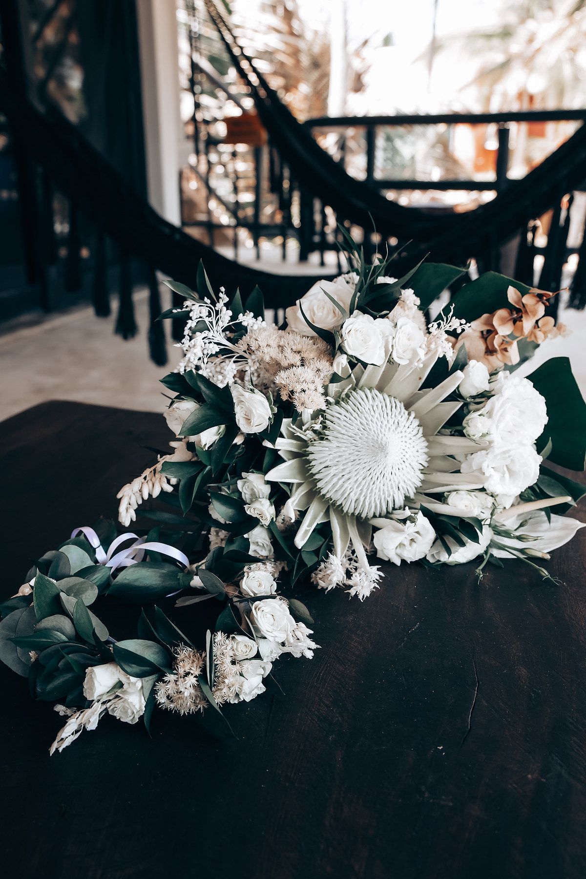 A series of moody black and white floral arrangements with dried white flowers against dark backgrounds.