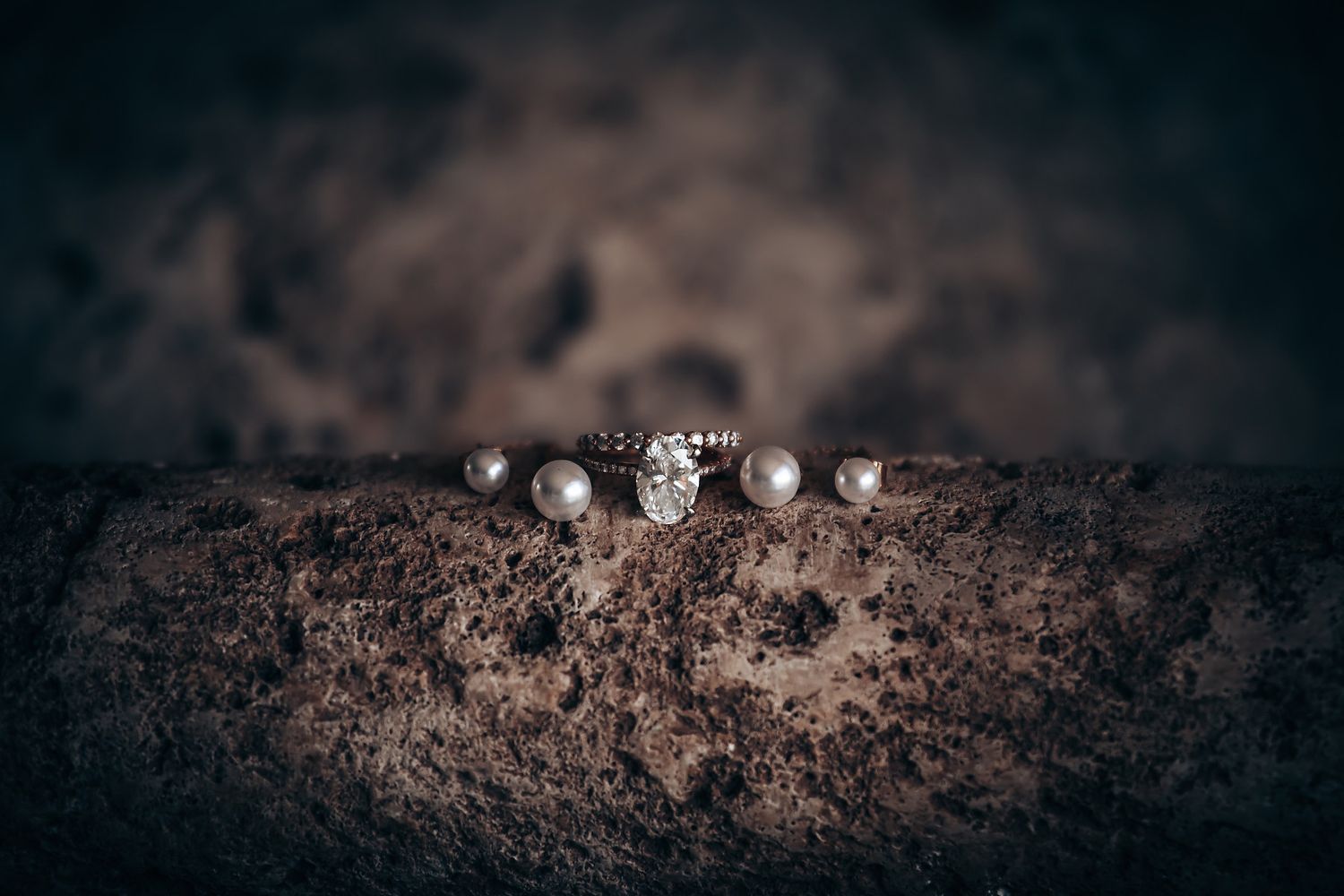 A series of moody black and white photographs showing dirt and stones arranged in a horizontal line.