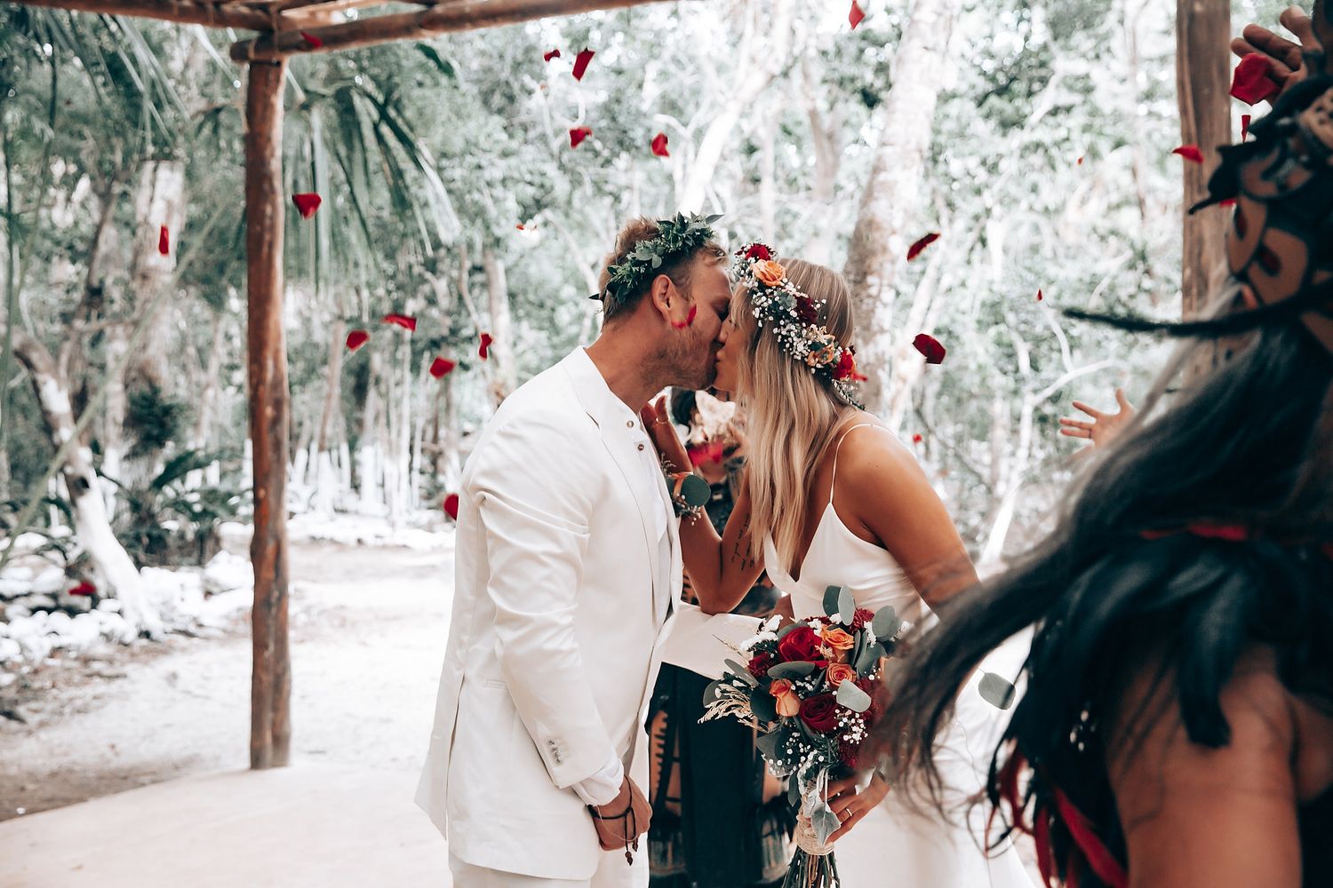 Wedding celebration in a forest setting with wooden structures and natural decor.