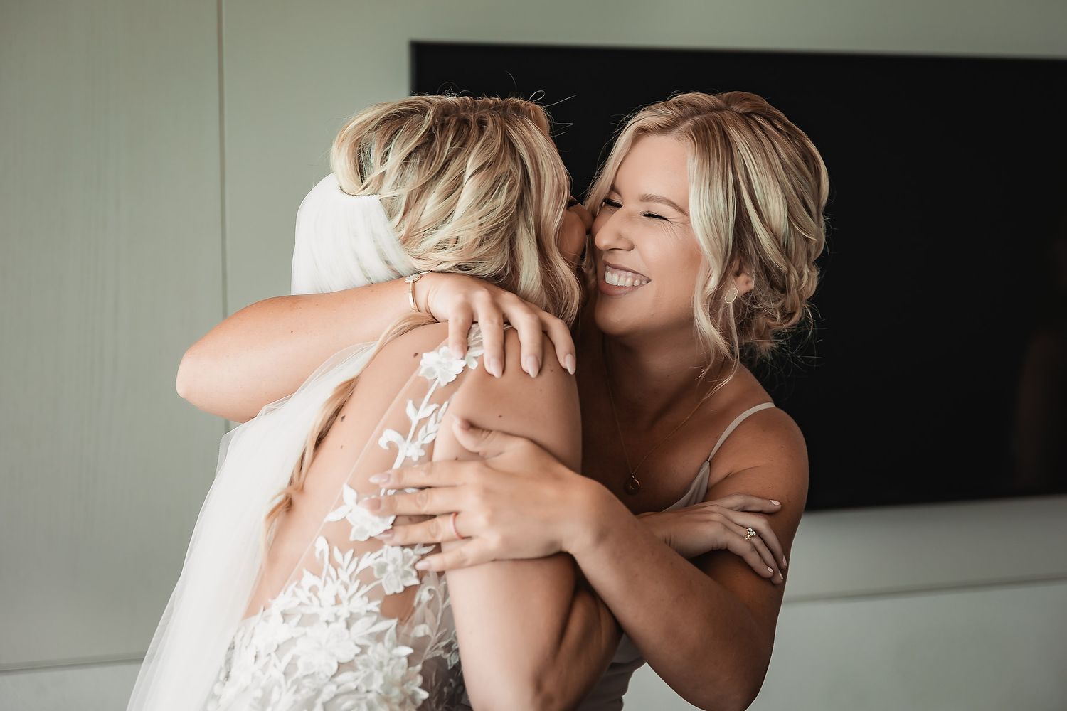 Wedding party members embrace in a series of candid pre-ceremony moments wearing neutral-toned dresses.