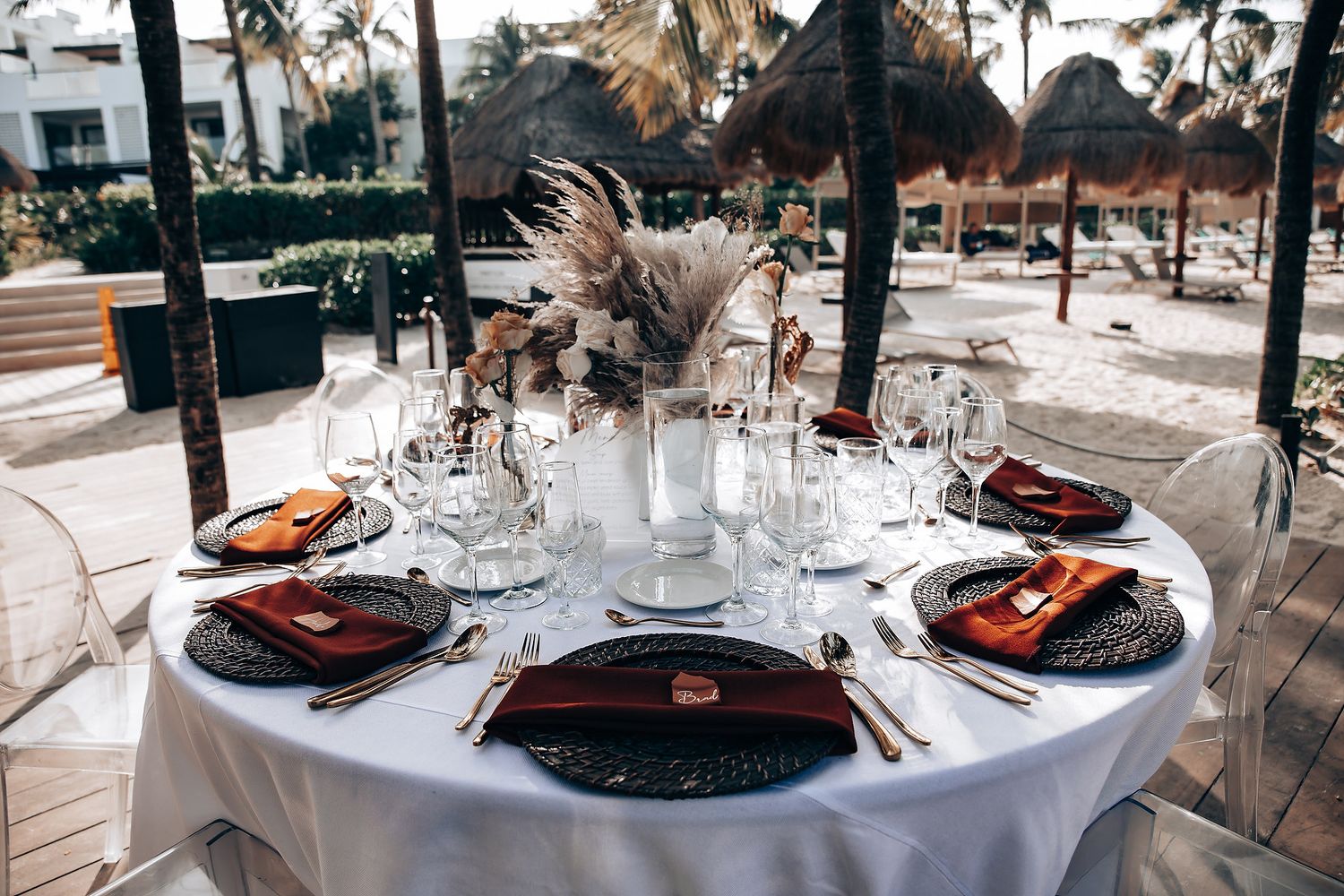 Elegant wedding reception tables set with black plates and orange accents.