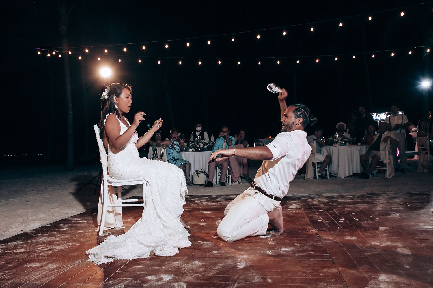Wedding couple performing special dance routine on outdoor dance floor at night.