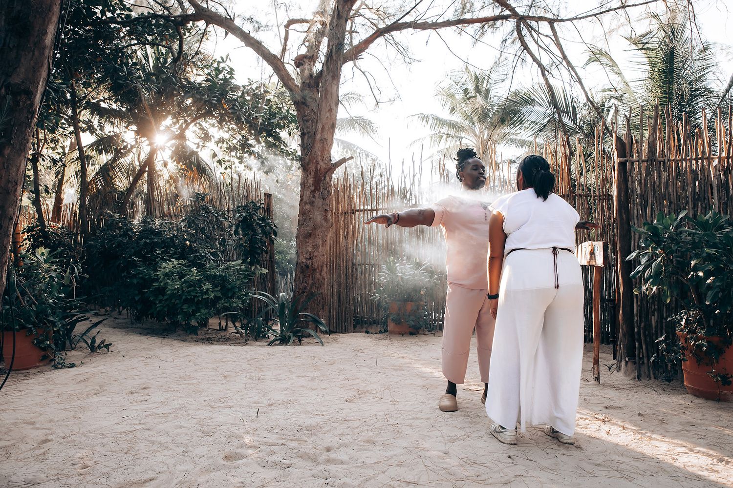 A couple walks together on a path in a lush, tropical garden.