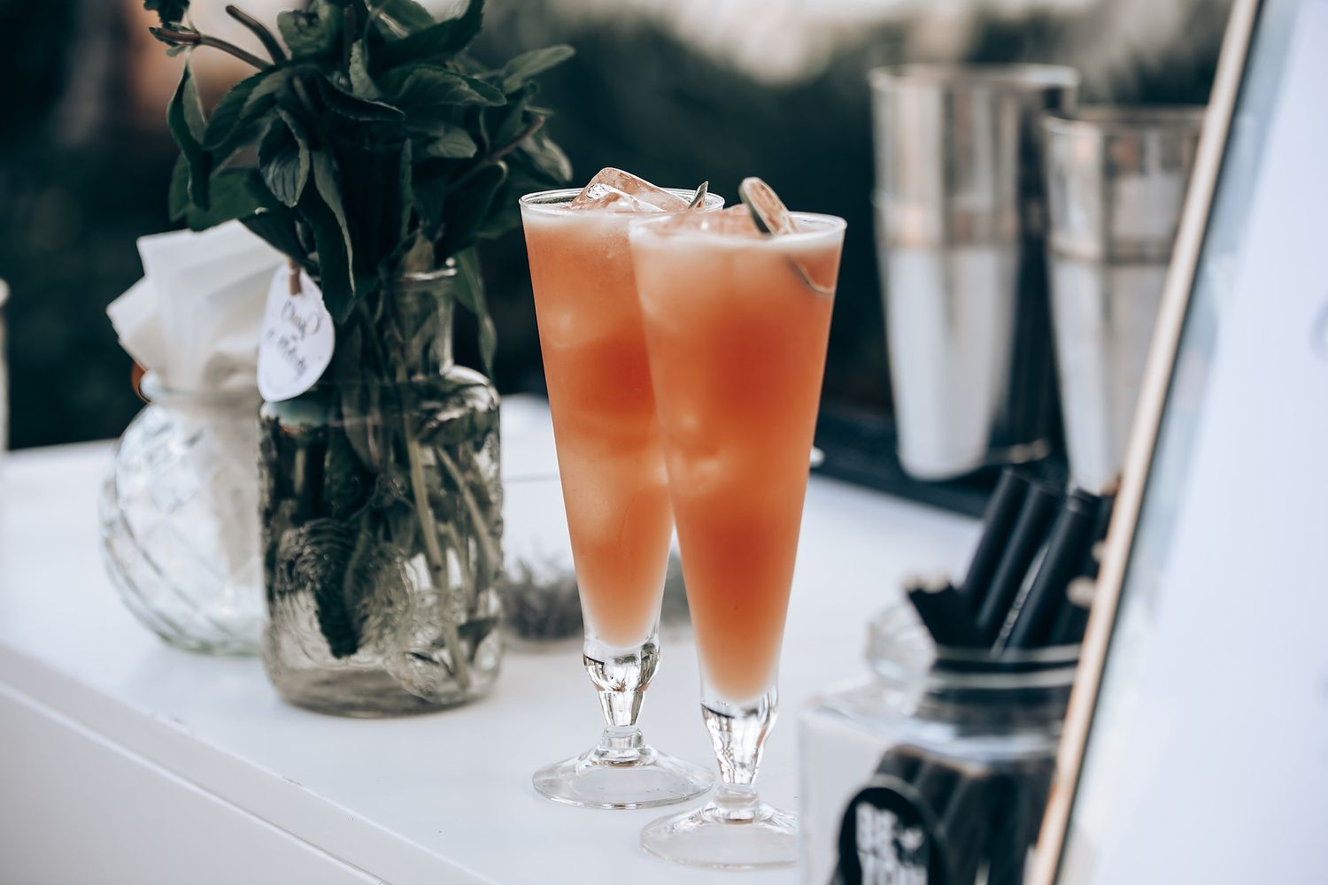 Peach-colored cocktails served in elegant glassware at a wedding reception.