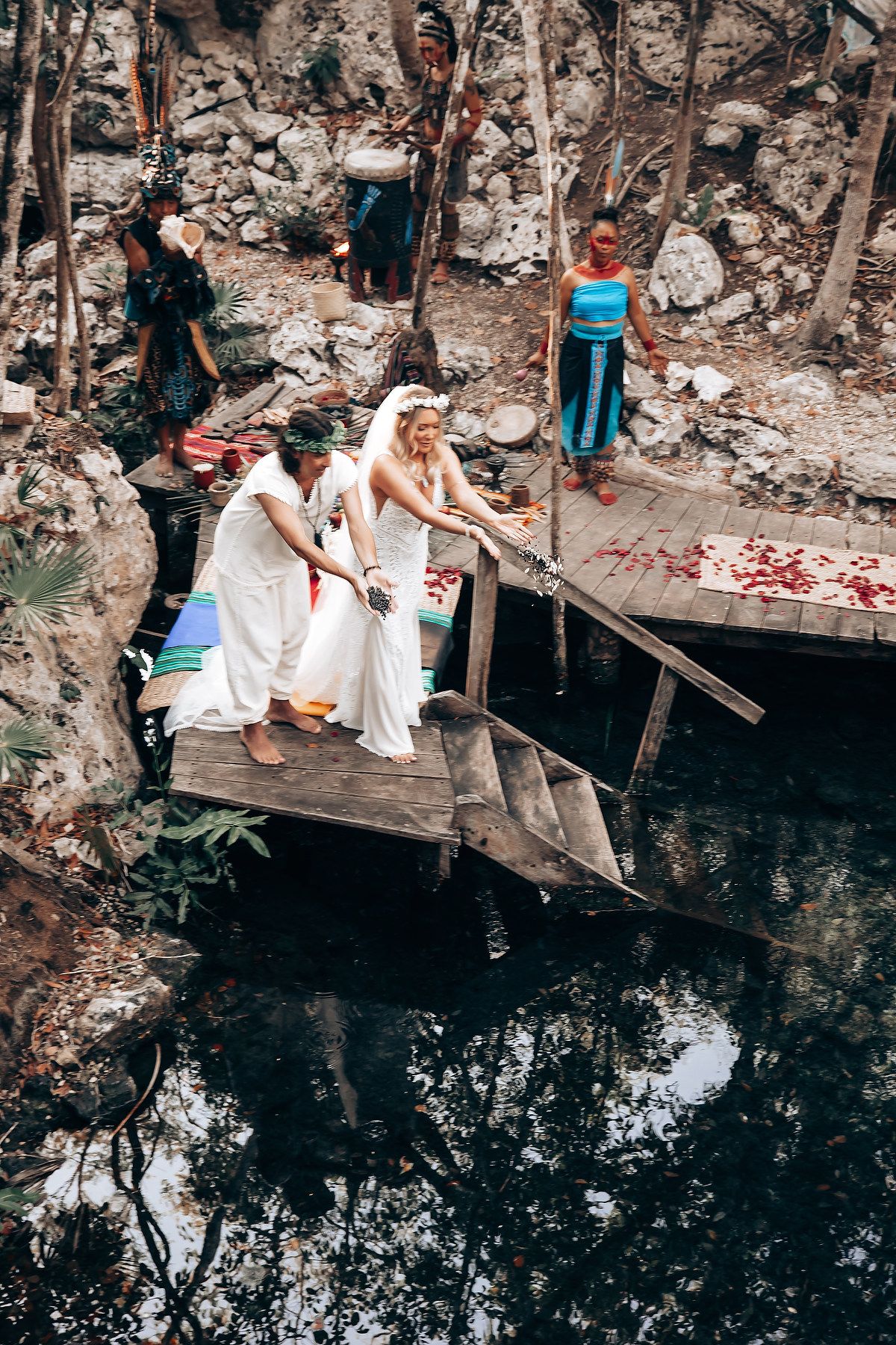 People in white clothing perform traditional washing rituals at a sacred cenote in Mexico.