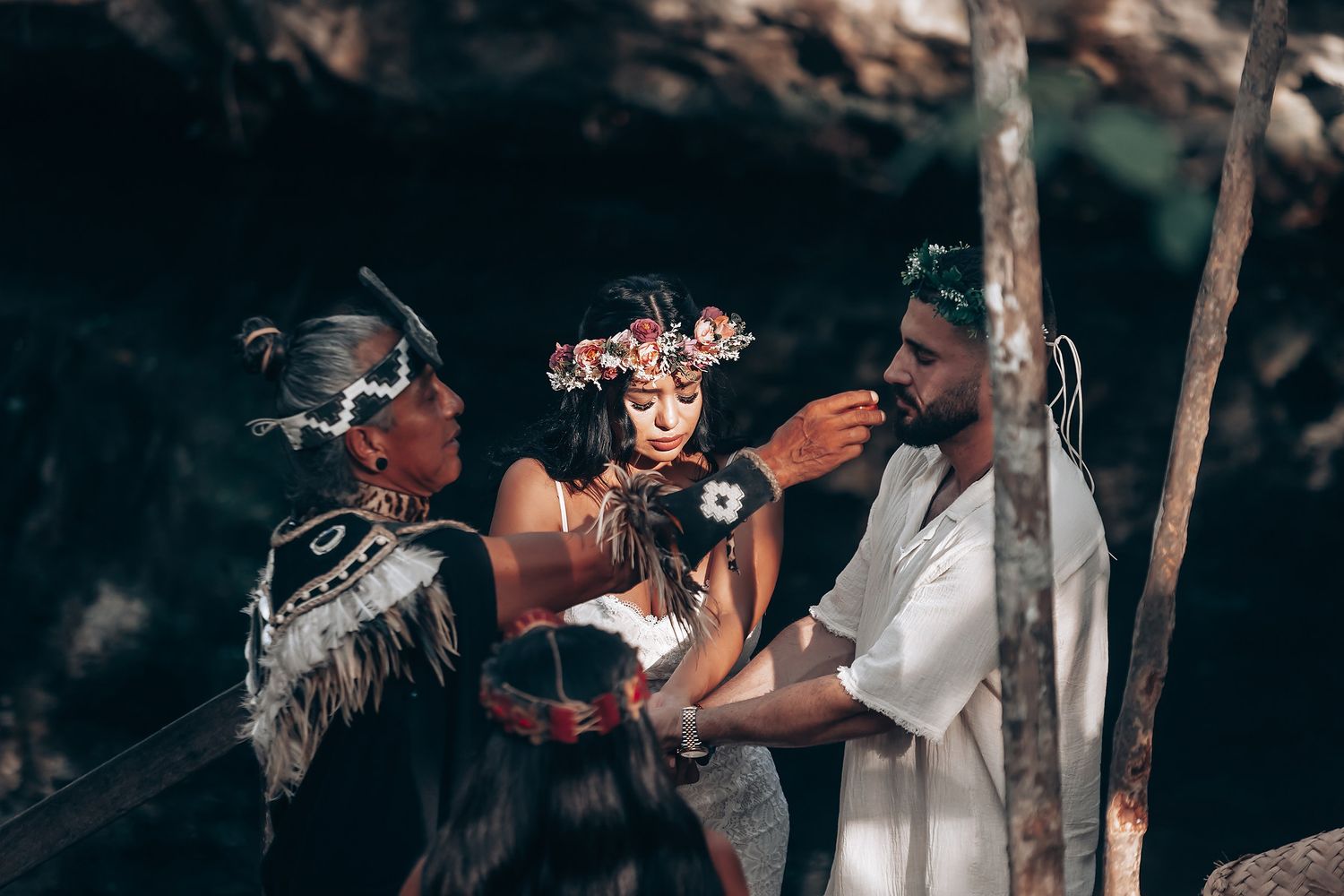 Wedding celebration in a wooded area with atmospheric lighting and smoke effects.