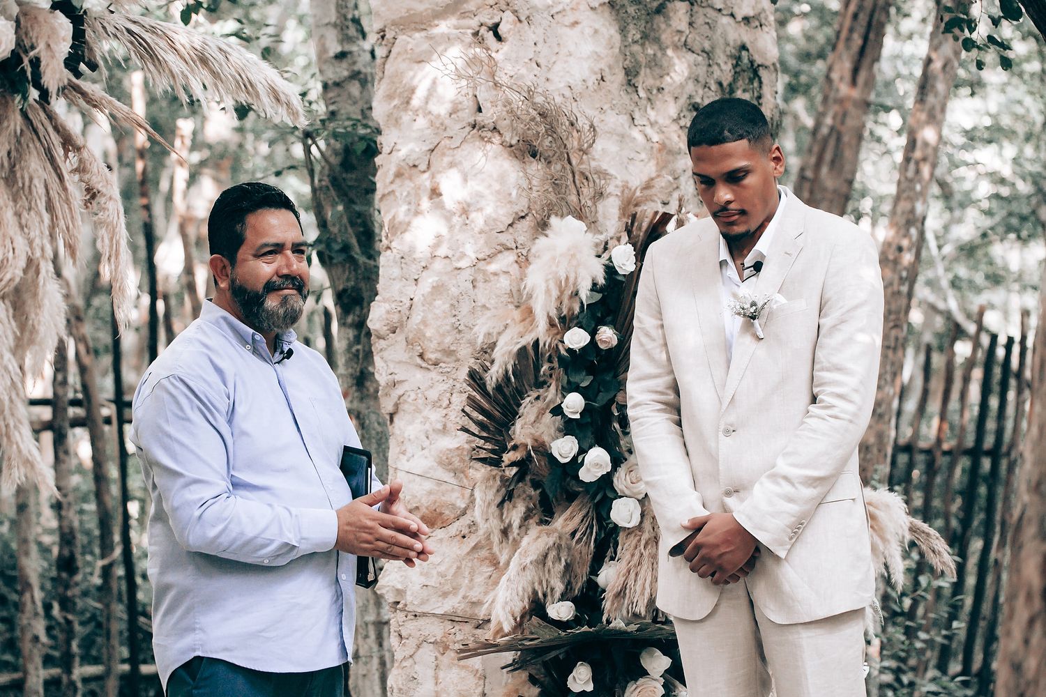 Wedding celebration in progress among tall trees and natural scenery.