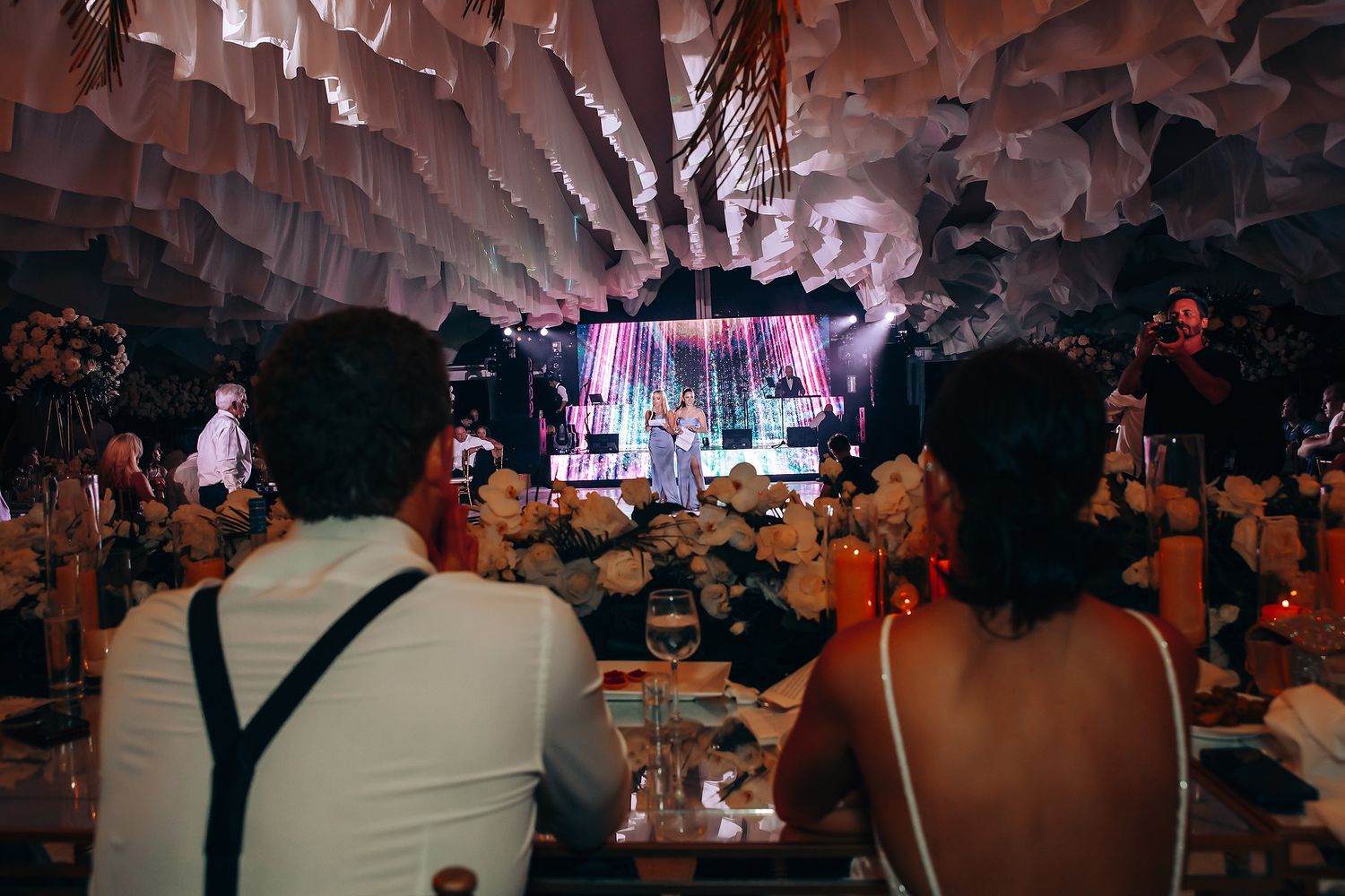 Wedding reception venue decorated with hanging paper lanterns and ambient lighting creating a romantic atmosphere.