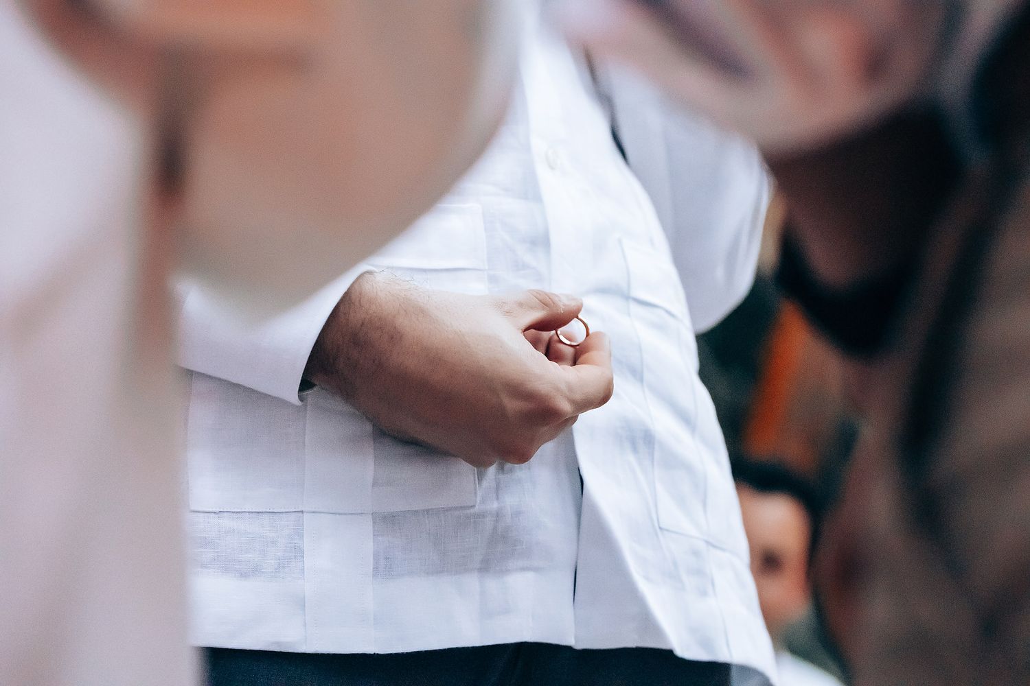 Wedding guests in white attire dance and celebrate together at an outdoor reception.