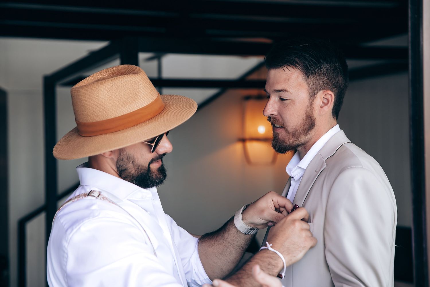 Wedding party members in white and beige attire sharing a candid moment together.