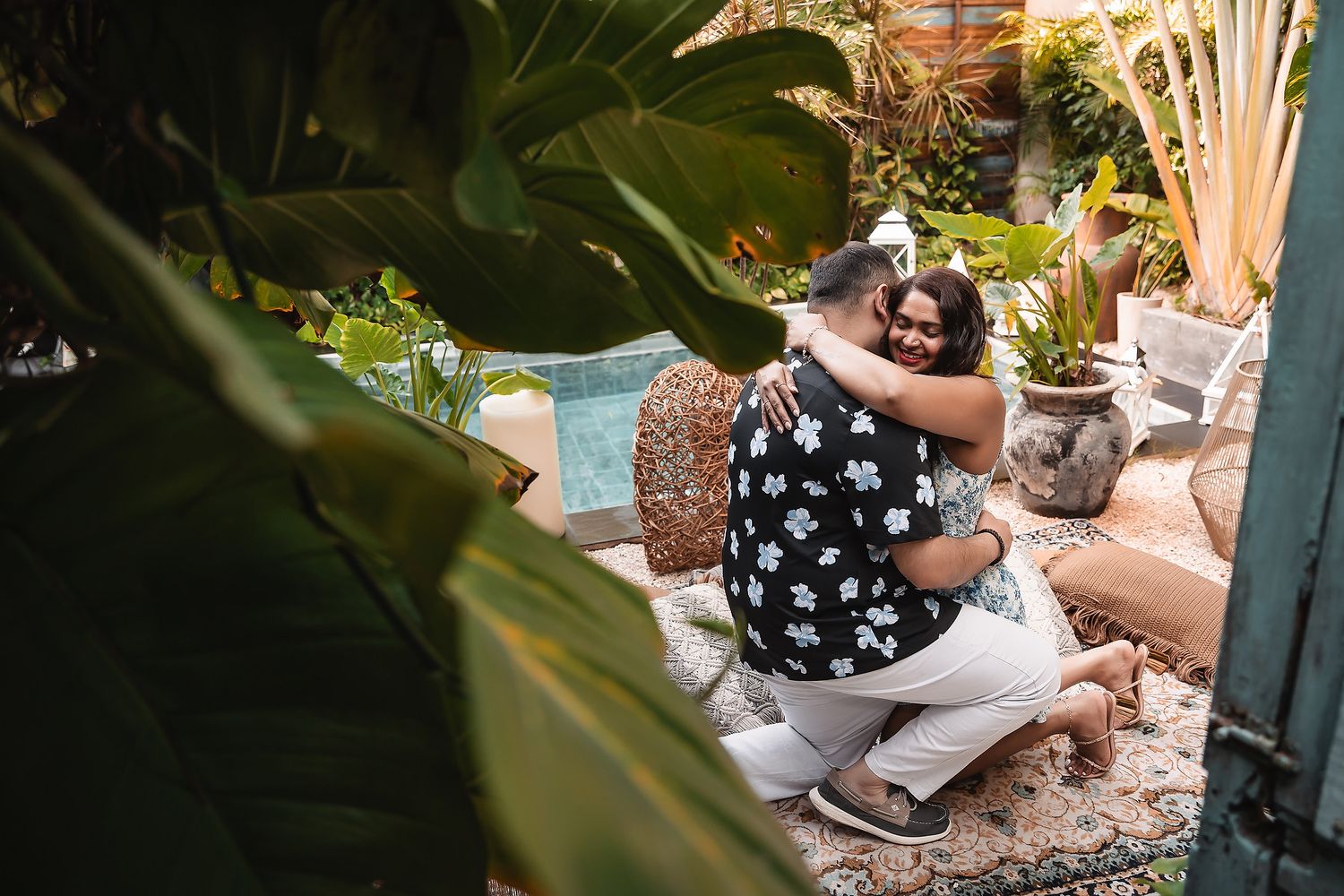 A surprise proposal moment captured in a tropical garden setting.