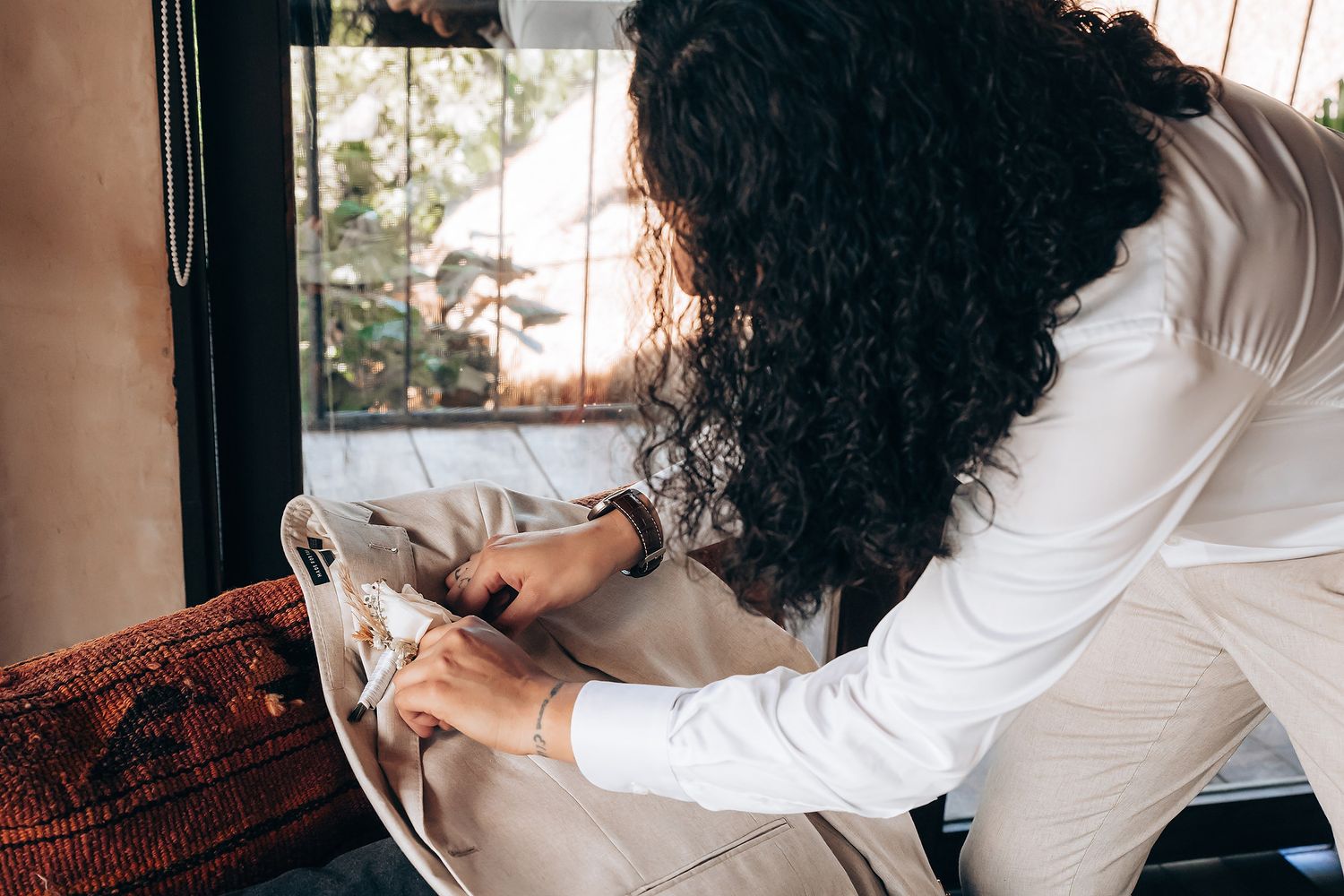 Multiple angles showing hands styling and arranging white clothing in natural window light.