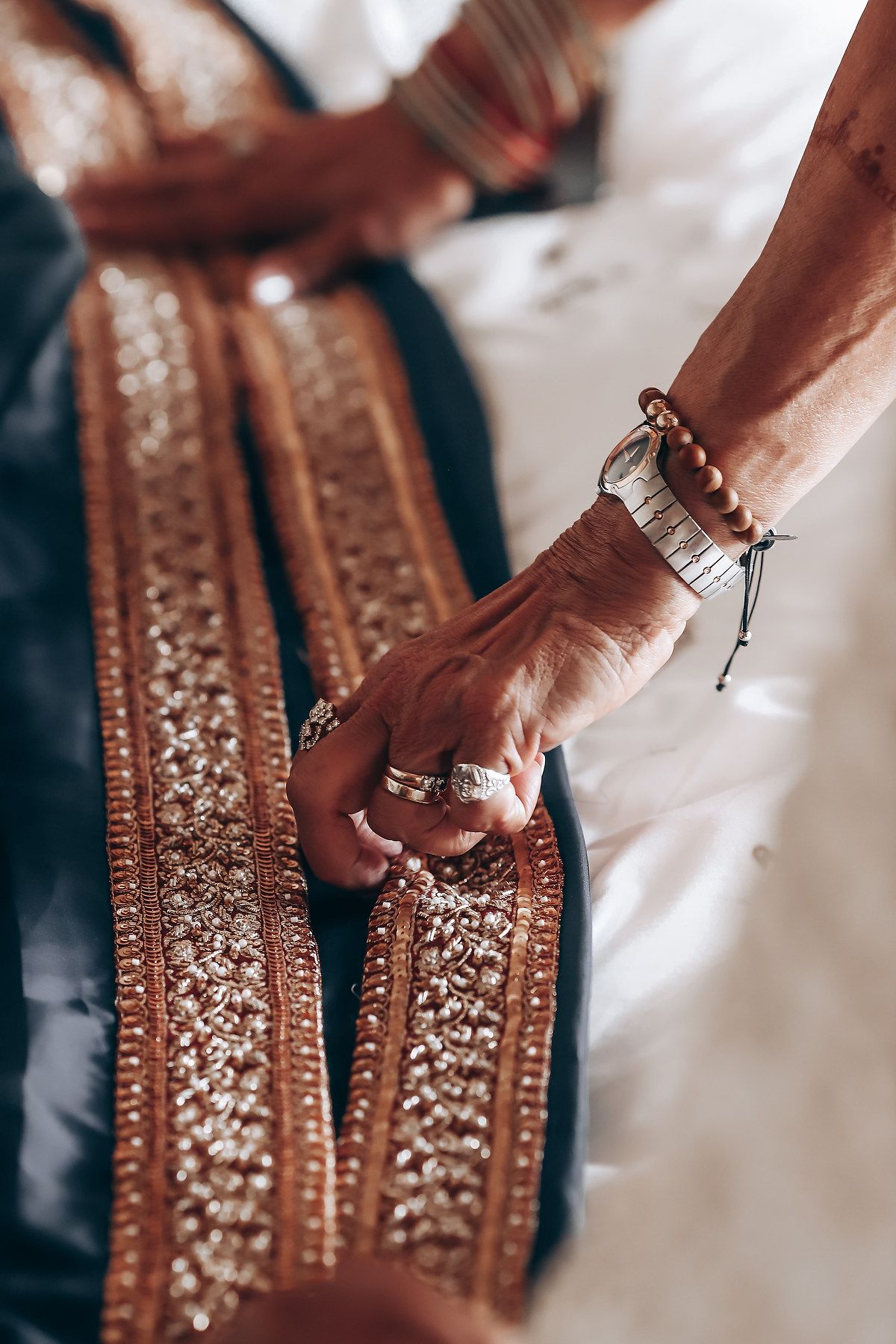Close-up shots of hands adorned with traditional Indian bridal jewelry and intricate henna designs.