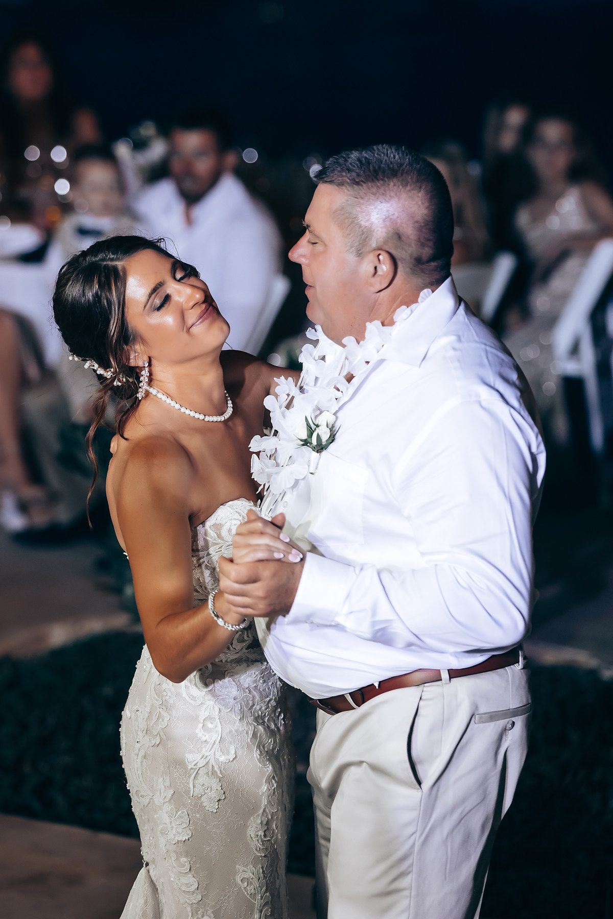 Couple sharing their first dance at their evening wedding reception.