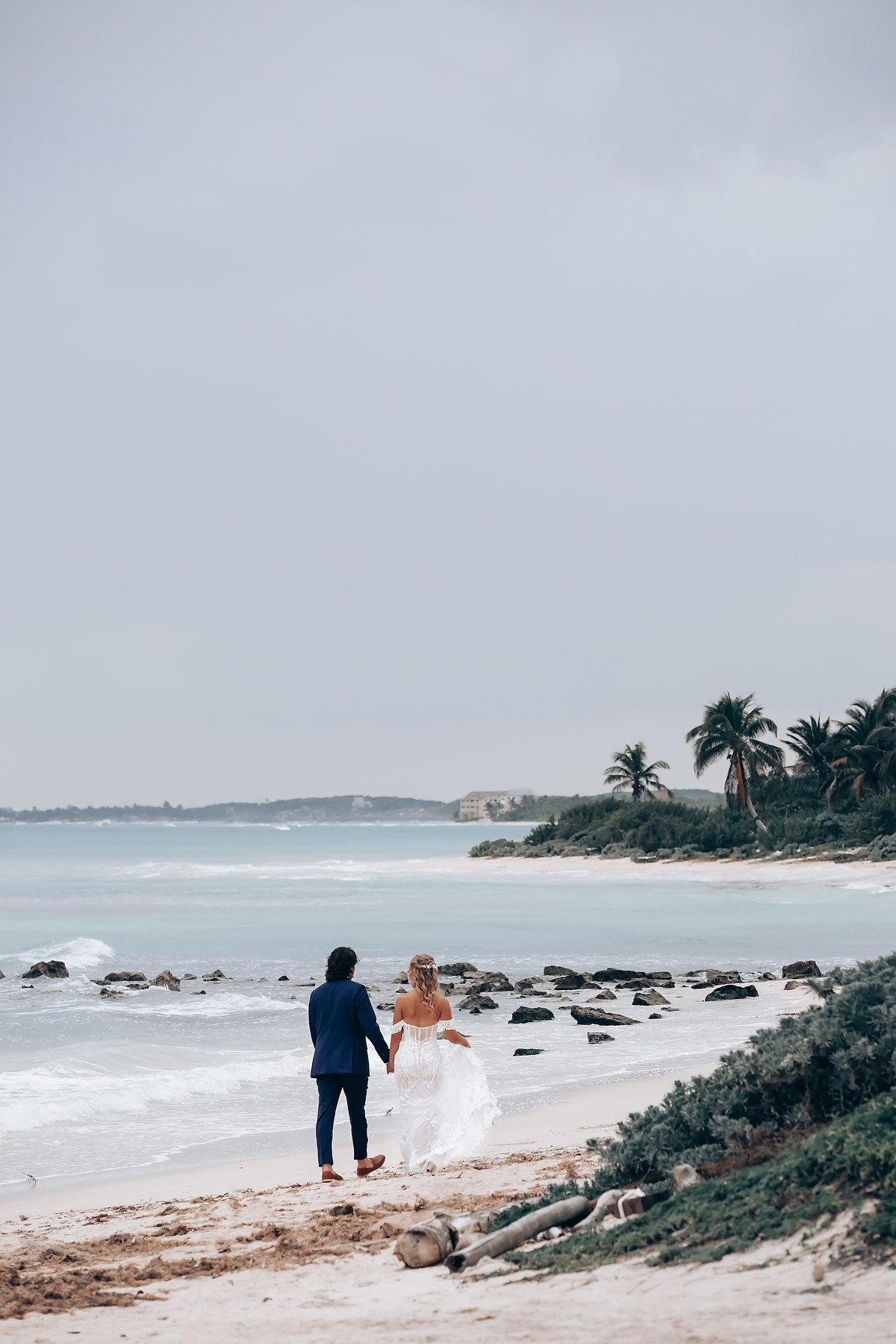 Coastal wedding photography session along a rocky beach shoreline.