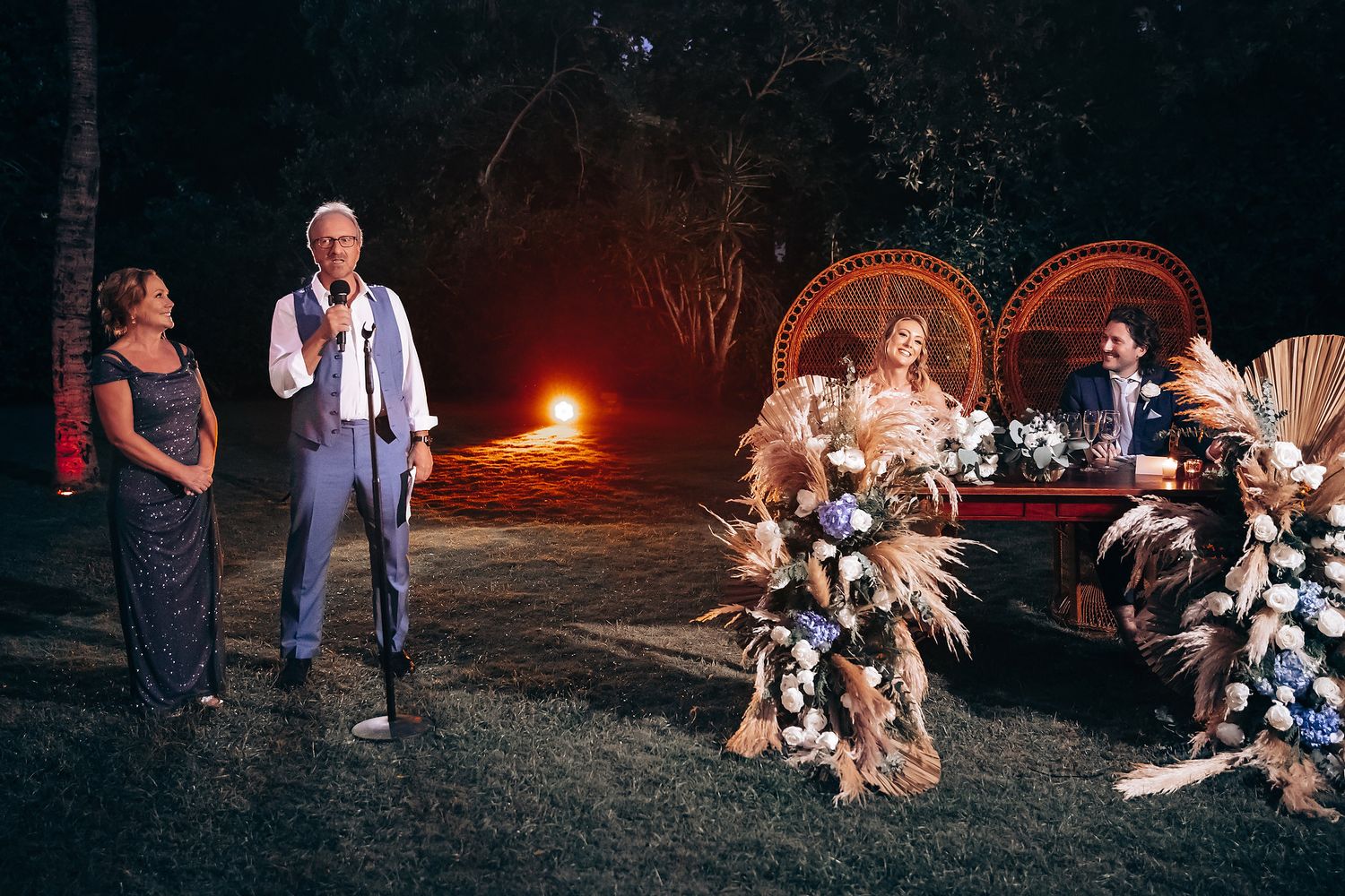 Evening wedding reception with boho-style decor and candlelight creating a romantic atmosphere.