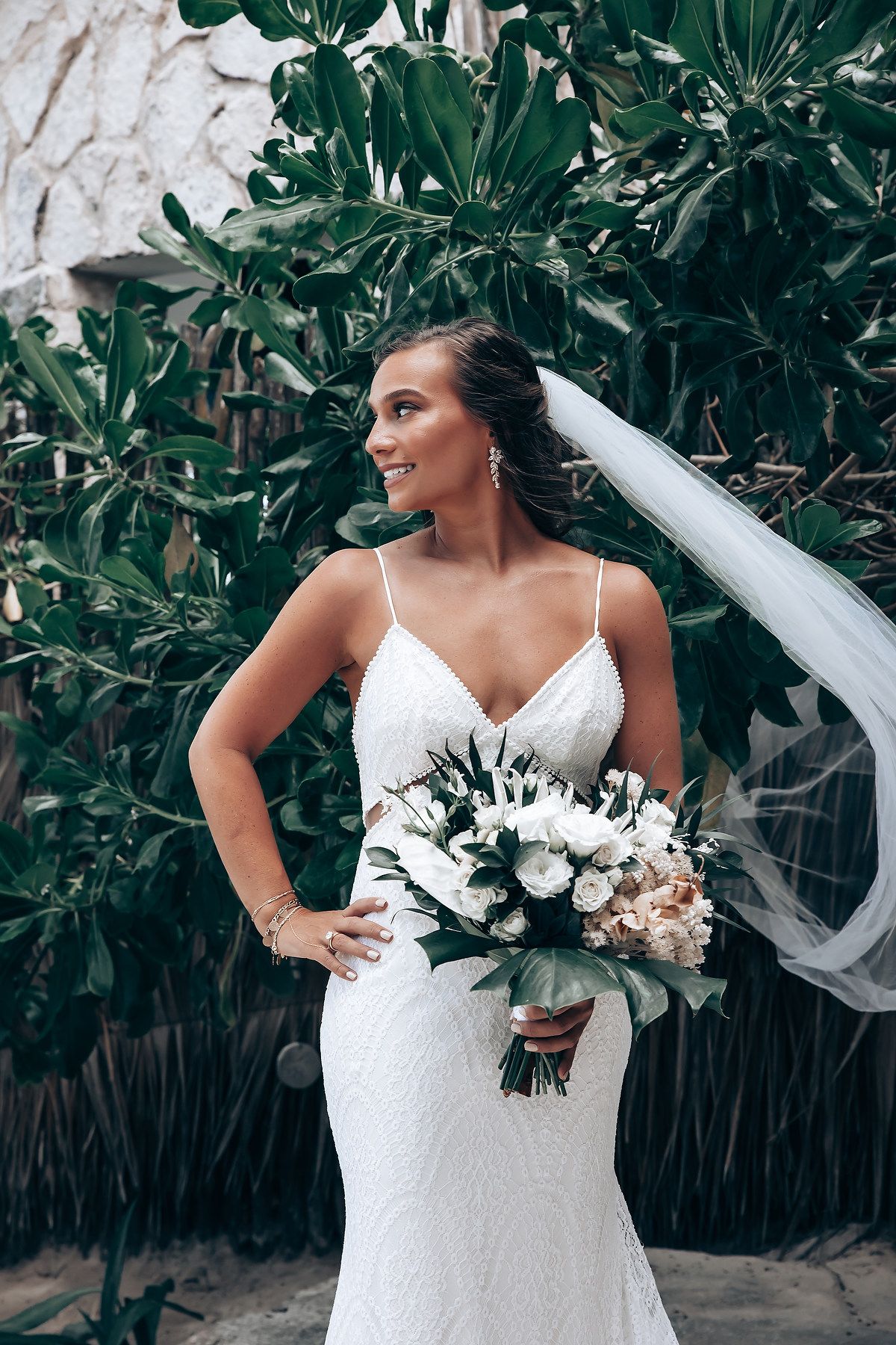 A bridal portrait series against lush tropical greenery showcasing a white wedding dress.