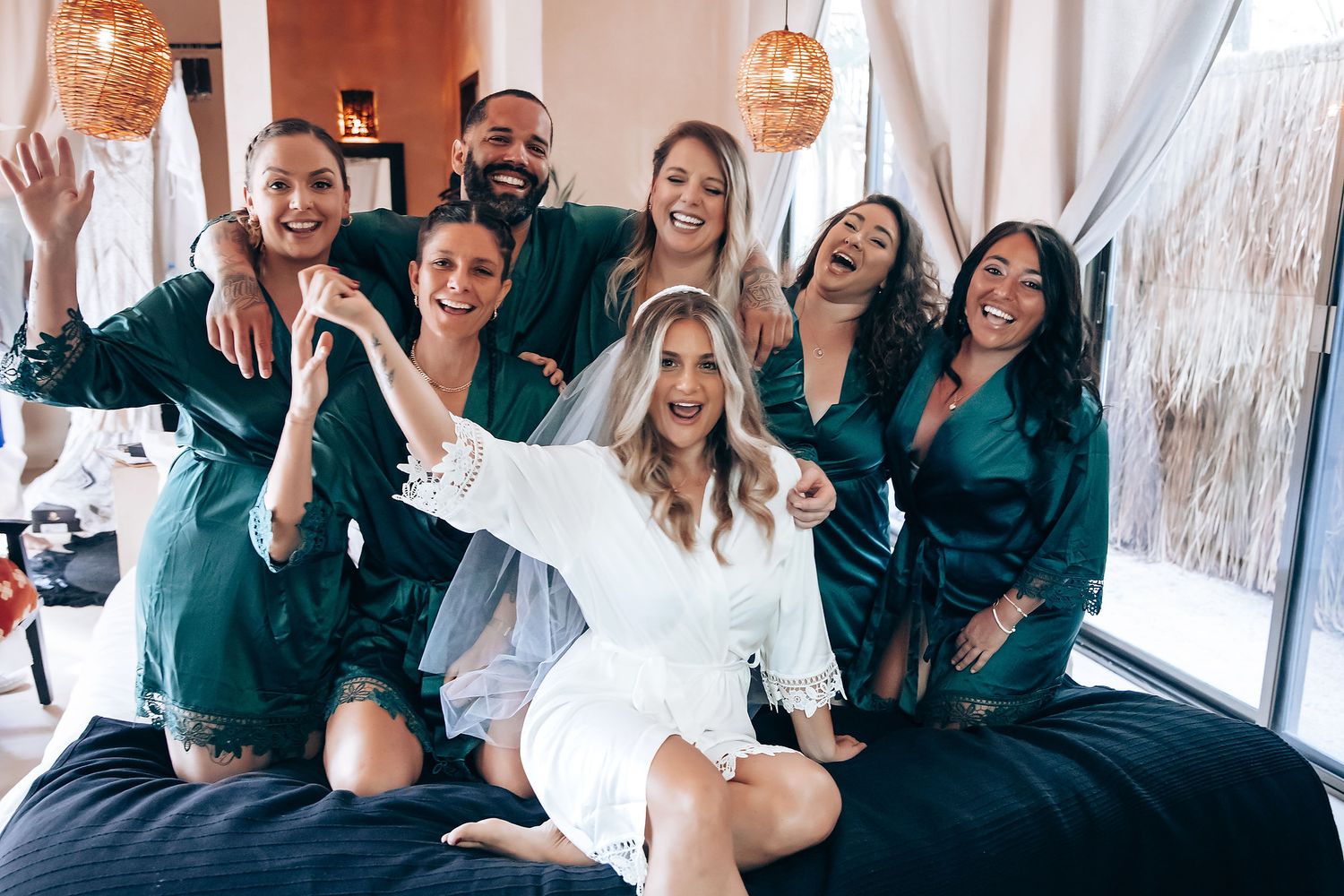 Wedding party celebration scene with group in matching emerald robes.