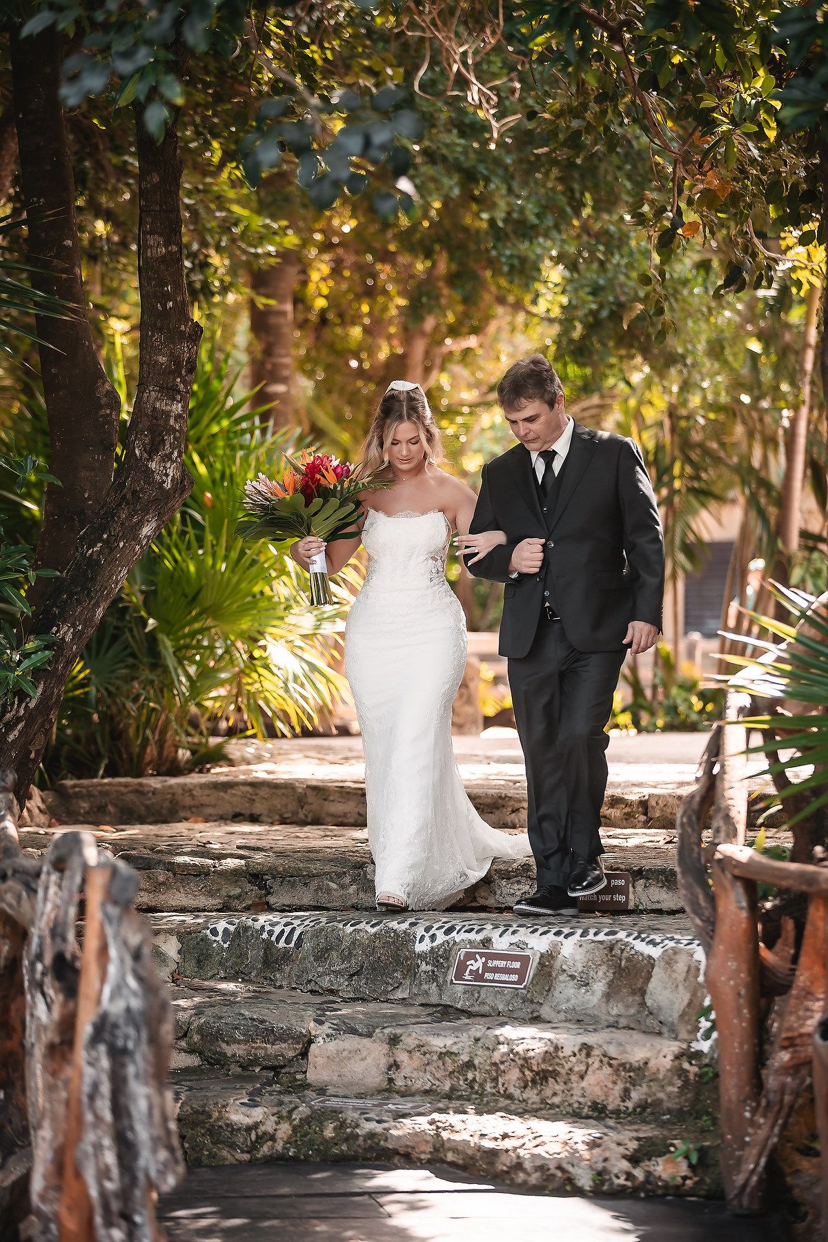 Intimate wedding moment captured on rustic stone steps in a garden setting.