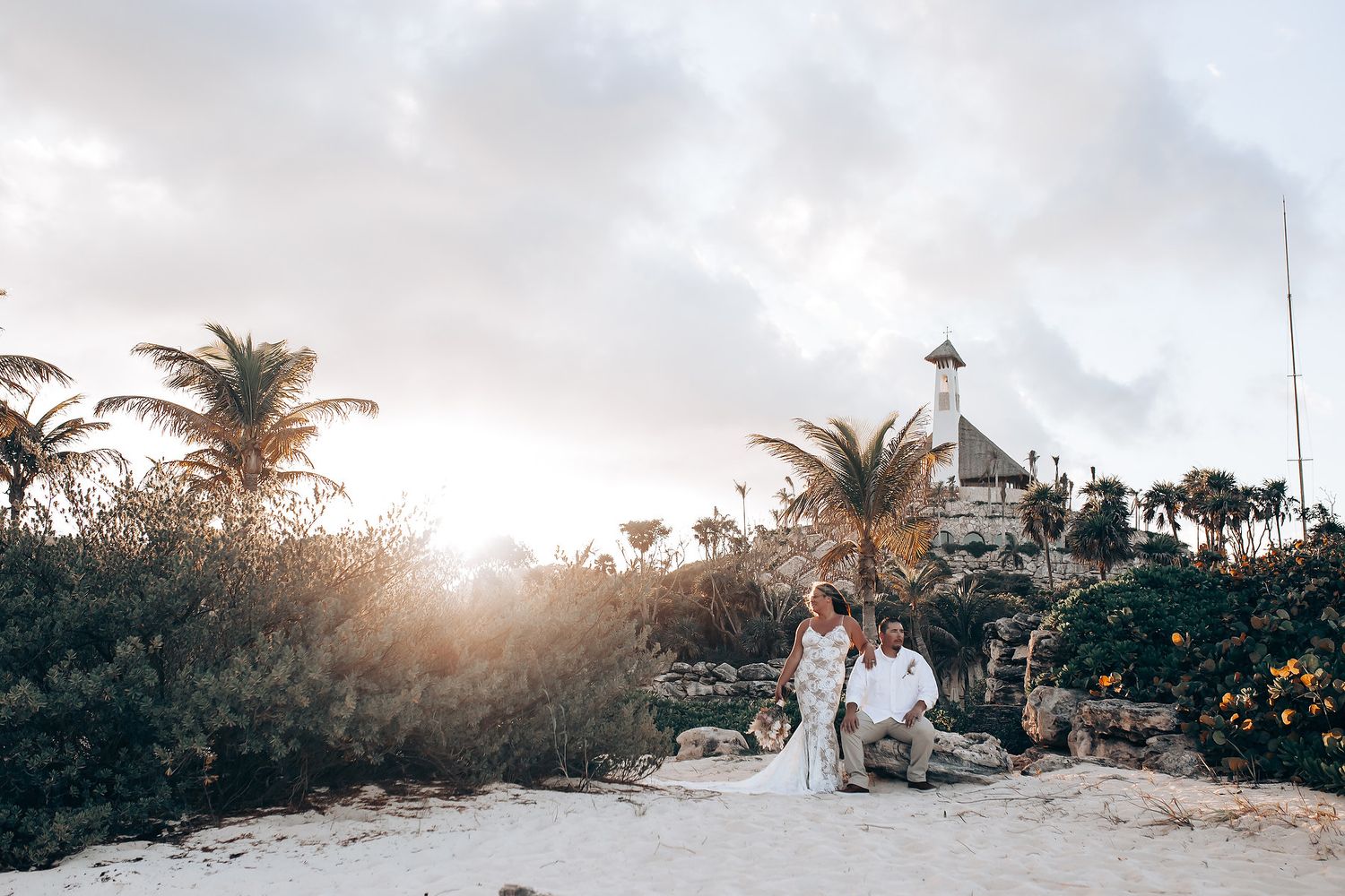 Wedding photoshoot at tropical beach location with palm trees and natural lighting.