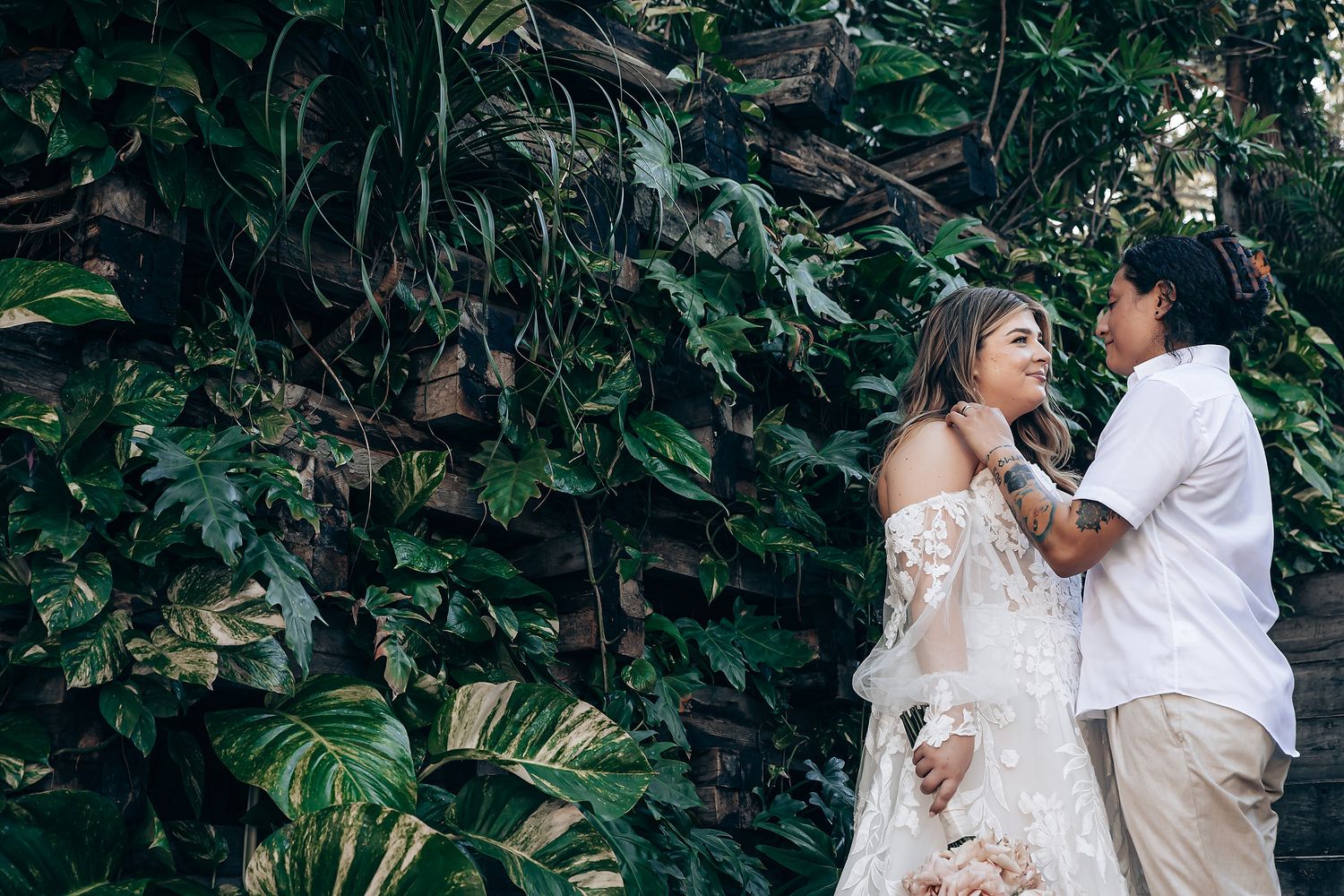Romantic couple embraces in a lush garden setting during an intimate wedding photoshoot.