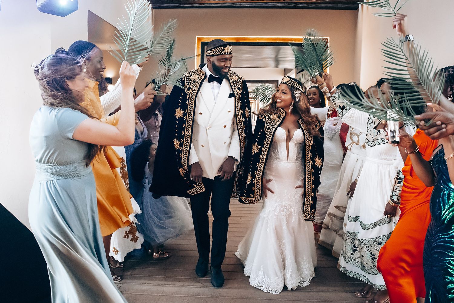 Wedding guests enjoy dancing and festivities at an indoor reception.