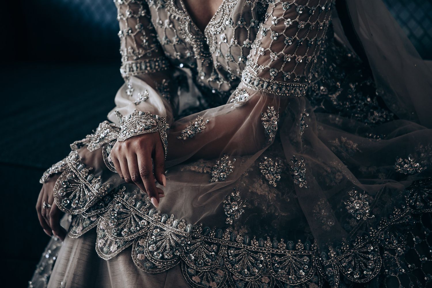 Close-up details of beaded embellishments and lace work on a wedding gown.
