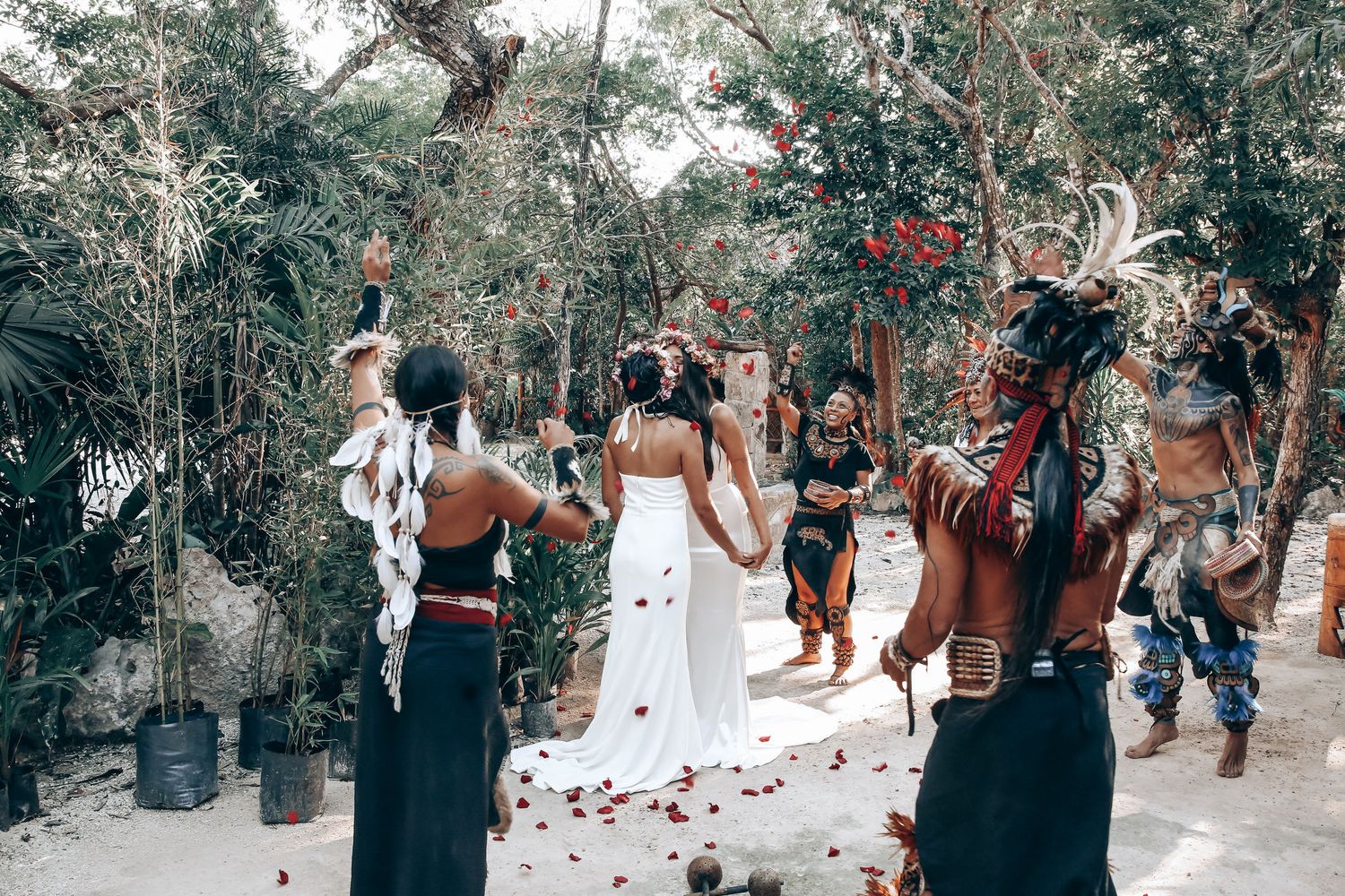 Garden ceremony setup with guests in tropical setting surrounded by lush vegetation.