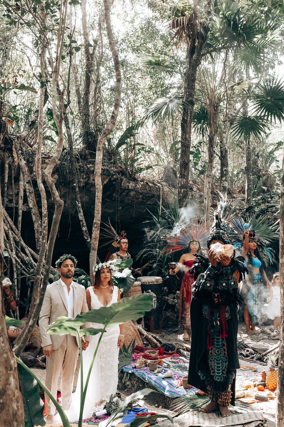 Guests gather in a lush outdoor forest setting during a wedding celebration.