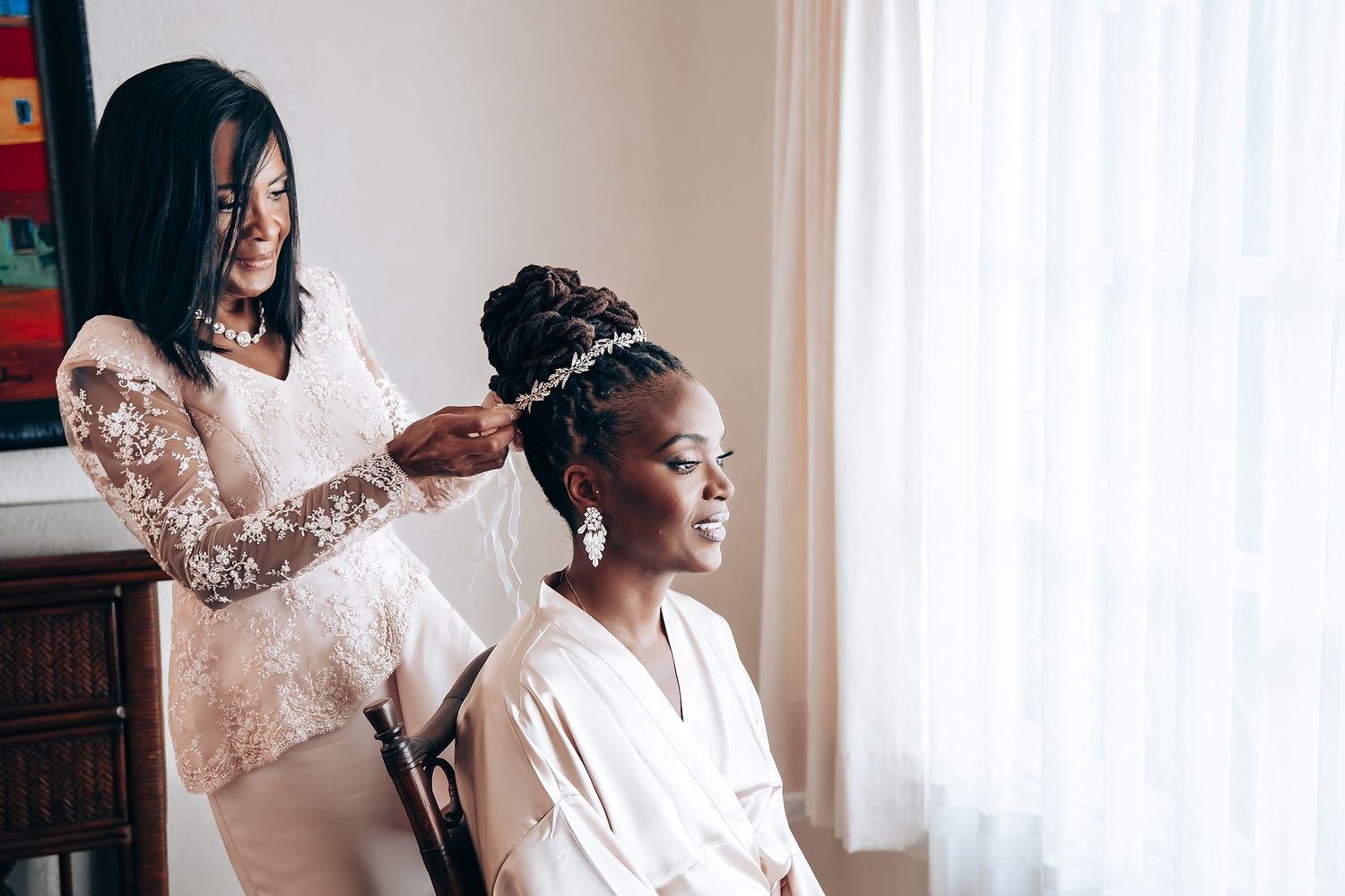 Wedding preparation scene showing hairstyling moment in natural light.