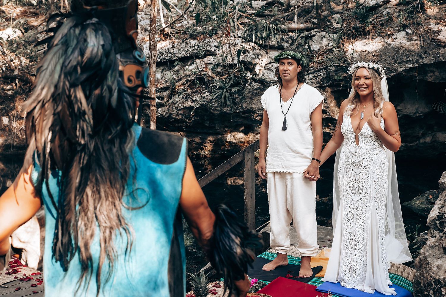 Wedding guests enjoying a celebration under a rustic outdoor canopy decorated with string lights.
