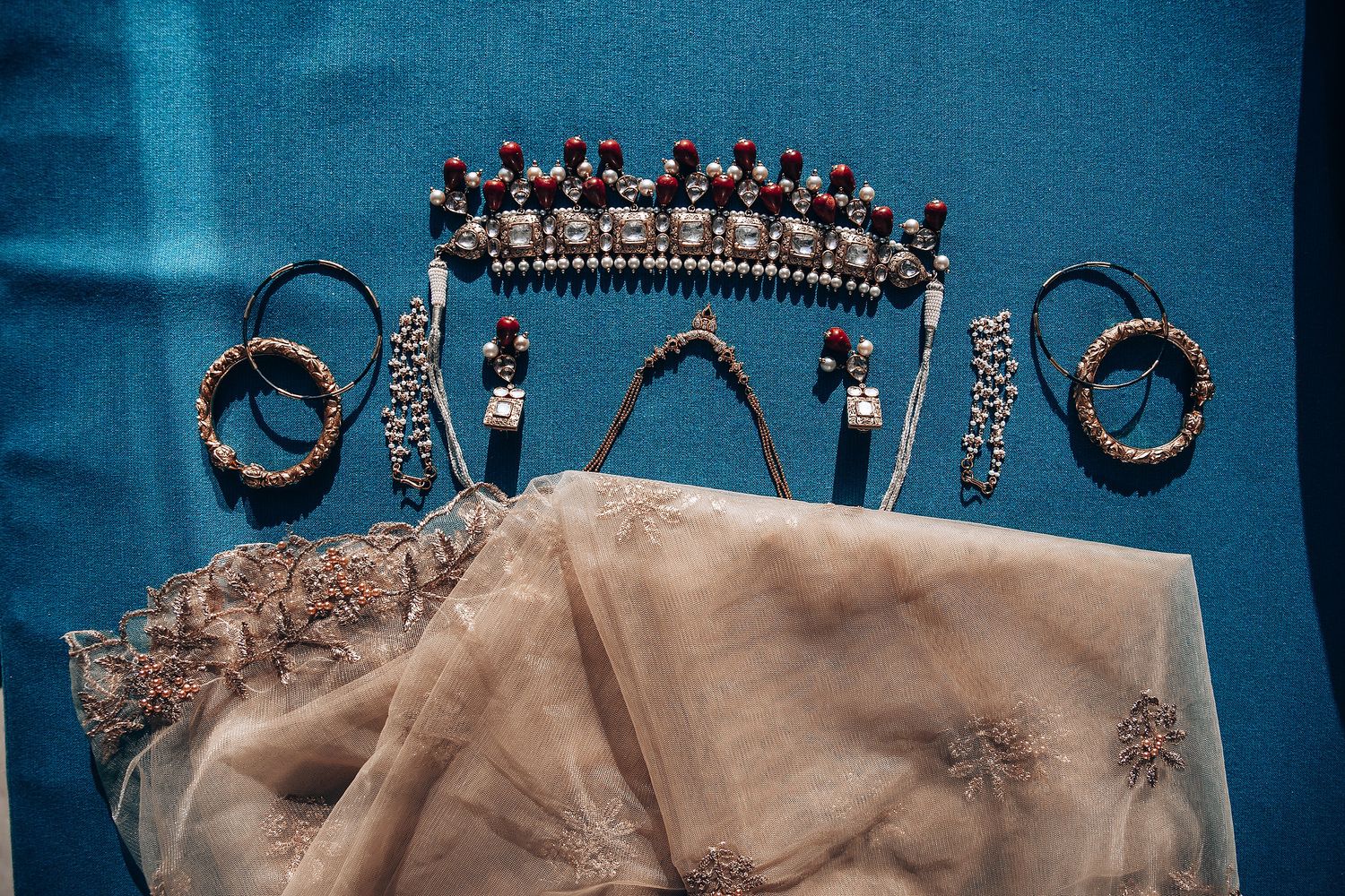 Elegant bridal jewelry and accessories including ornate headpieces and necklaces displayed on dark background.