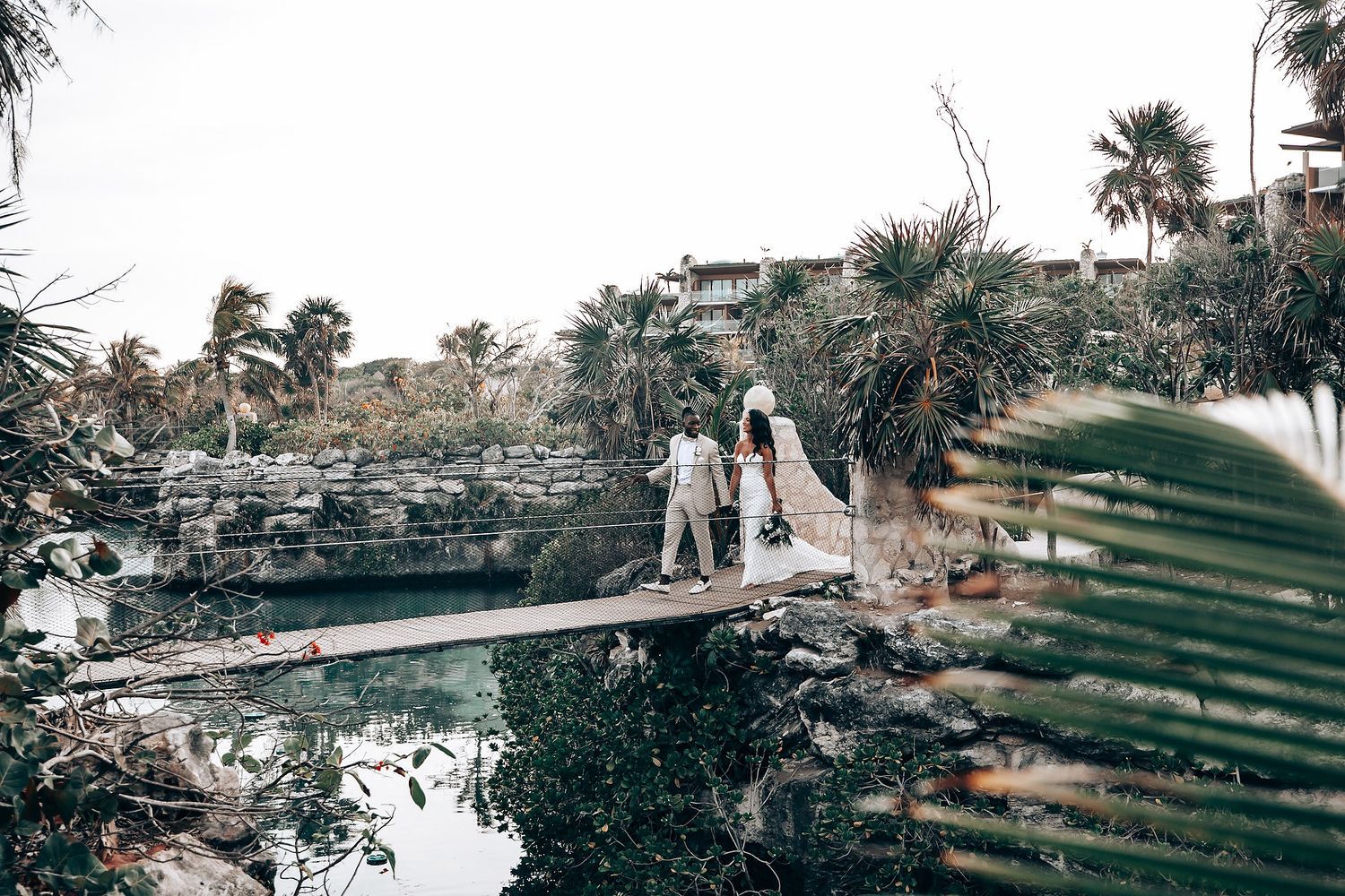 Scenic tropical wedding venue with palm trees and waterfront views.