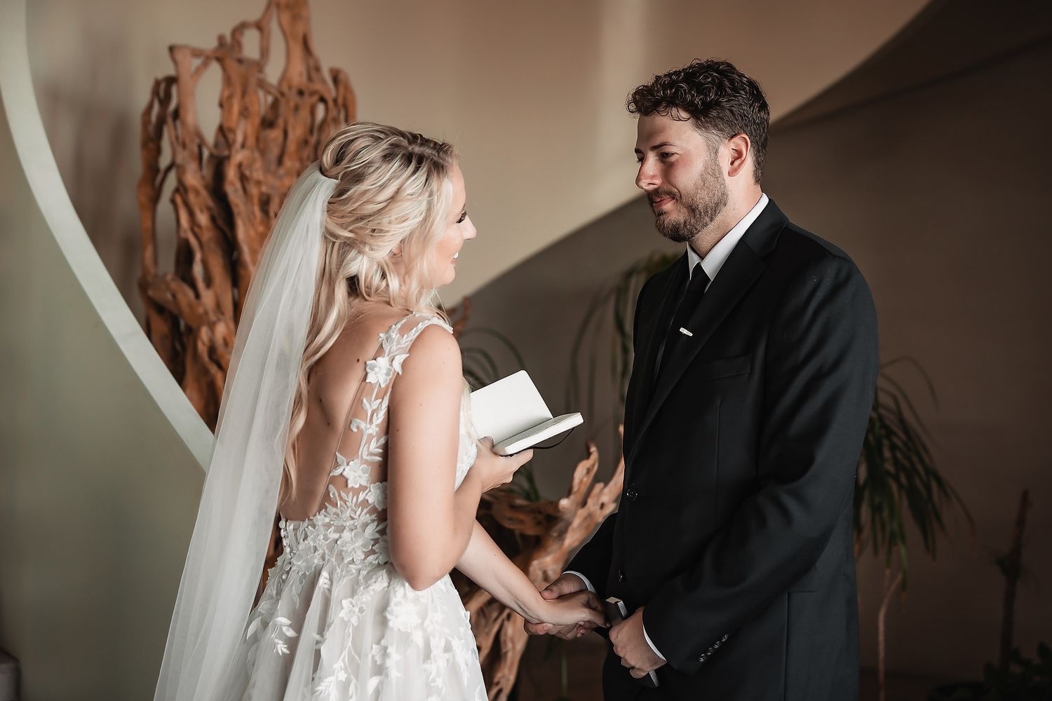 Wedding first look moment captured in warm lighting with rustic wooden decor.
