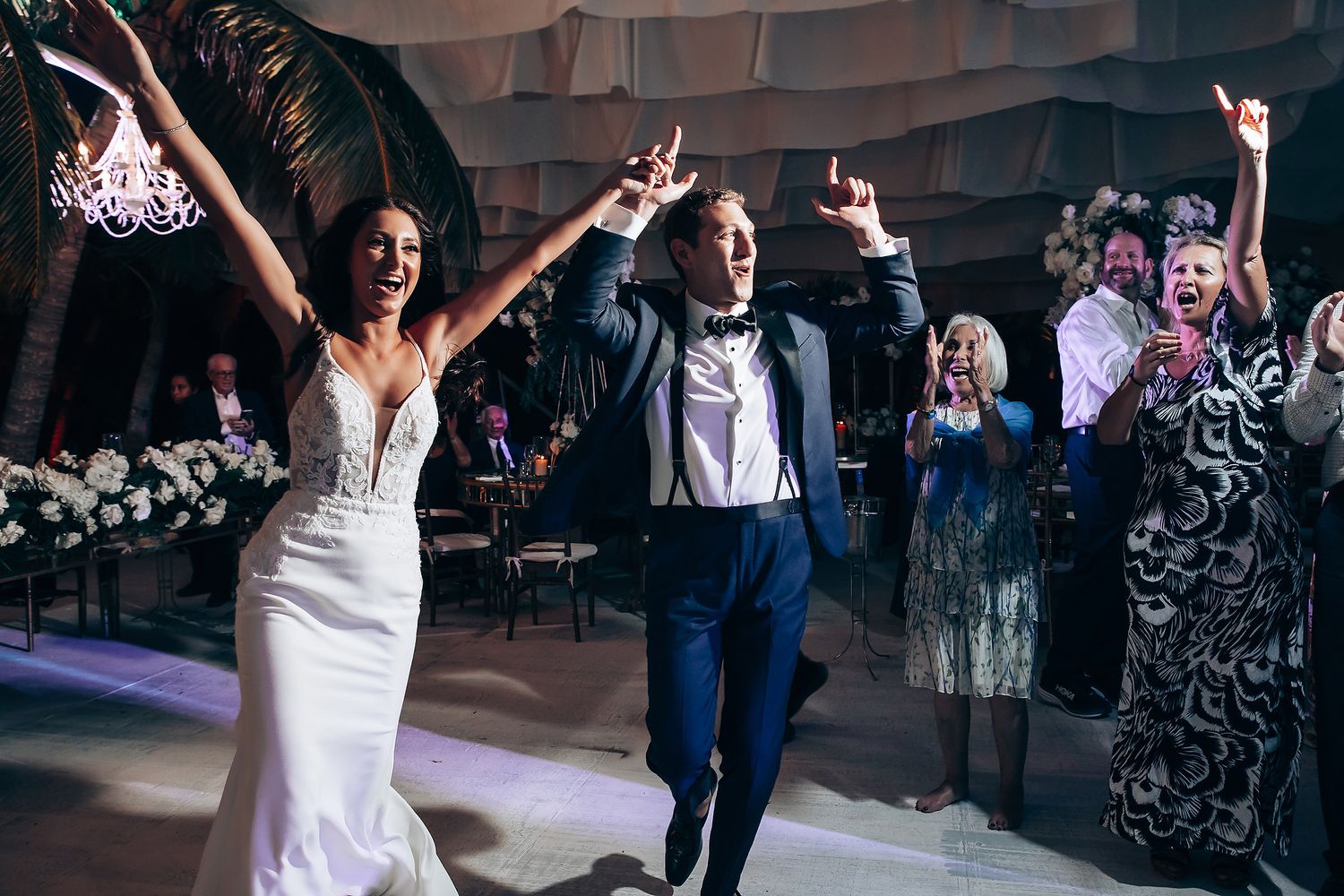 Wedding reception dance floor filled with celebrating guests in formal attire.