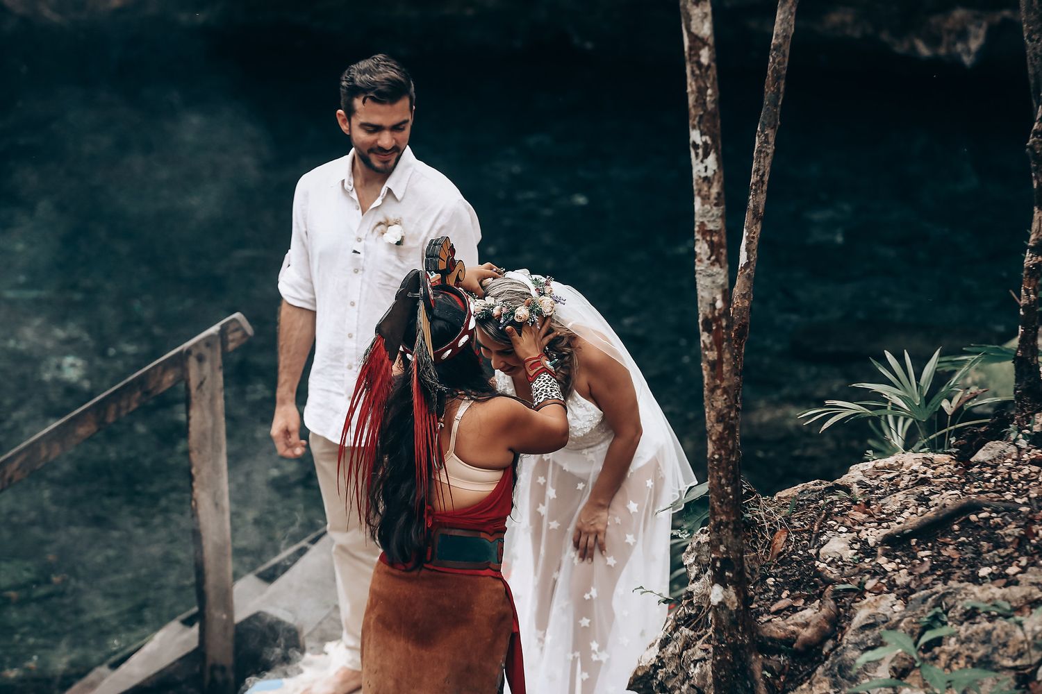 Outdoor ceremony taking place in a natural setting with trees and rocky terrain in the background.