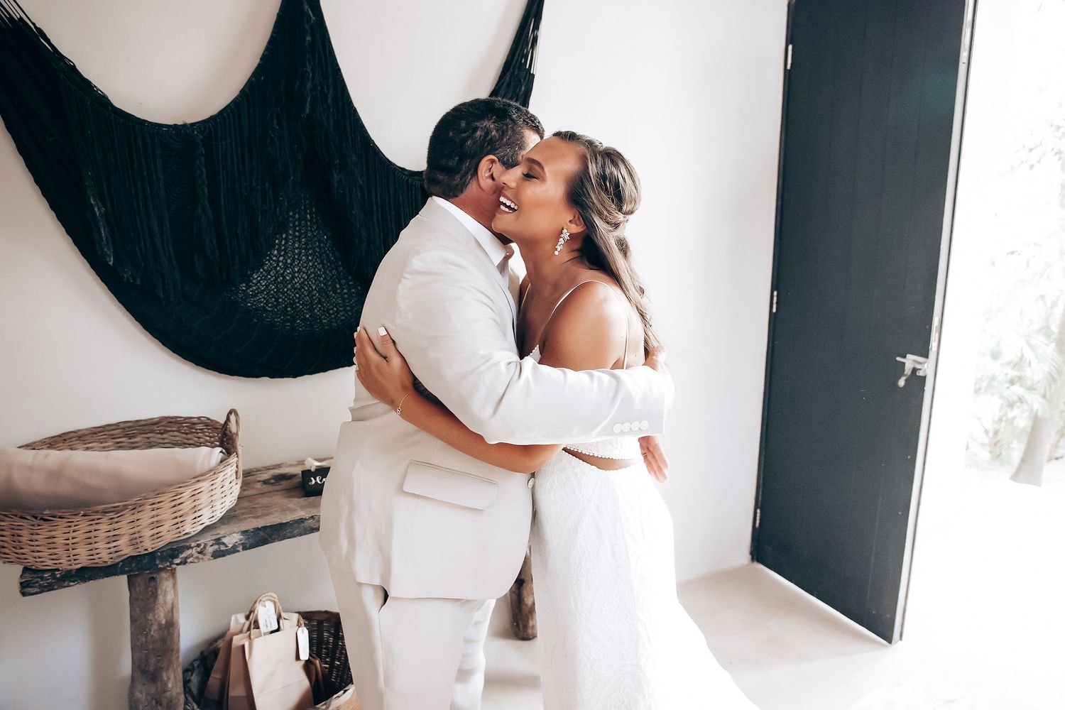 Intimate wedding celebration moment captured against white walls and modern decor.