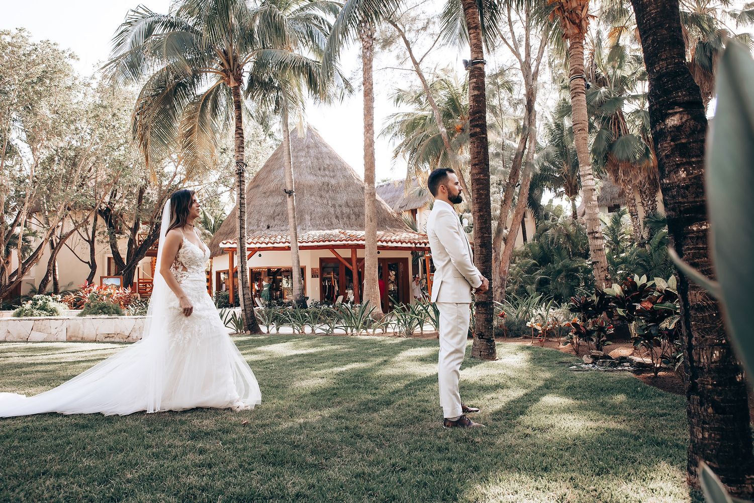 Wedding couple shares romantic moments in a lush outdoor garden setting with soft natural lighting and greenery.